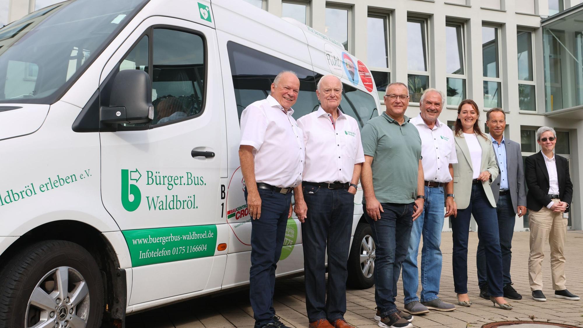 Der Bürgerbus ist da – auch zum Waldbröler Bürgerdorf am Alsberg ist das Fahrzeug auf Bestellung gefahren. Das Fahrzeug erwarten (von links) Leo Wehling, Reinhard Grüber (beide Bürgerbusverein), Thomas Rothe (Bezirksregierung), Michael Jaeger Bürgerbusverein), Bürgermeisterin Larissa Weber, Frank Herhaus (Obebrergischer Kreis) und Corinna Güllner (Ovag).
