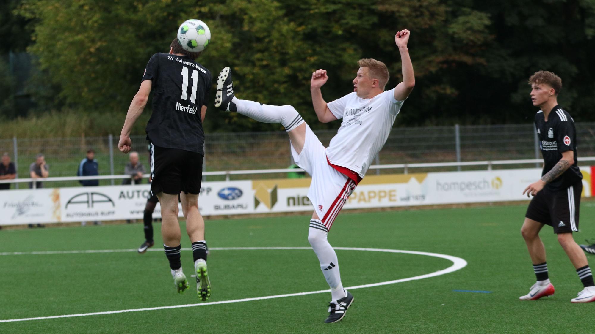 Mit erhobenem Bein geht Jakob Raudszus in den Zweikampf und versucht den Ball in Höhe des Hinterkopfs von Jonas Küpper zu treffen.