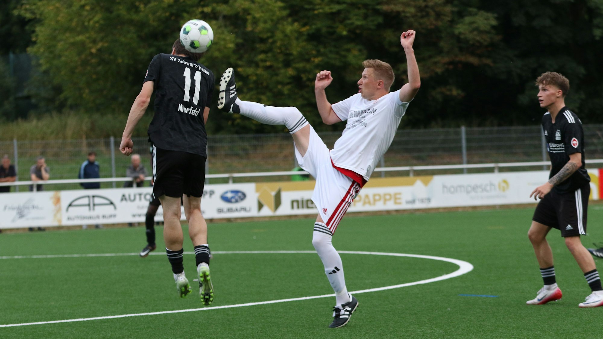 Mit erhobenem Bein geht Jakob Raudszus in den Zweikampf und versucht den Ball in Höhe des Hinterkopfs von Jonas Küpper zu treffen.