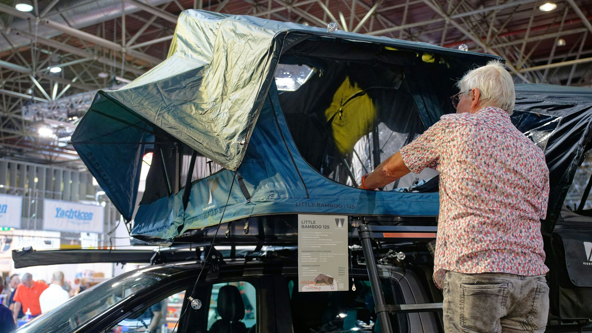Ein Besucher betrachtet beim ´Caravan Salon - Messe für Caravaning, Camping und Outdoor-Tourismus» das Dachzelt ´Vickywood Little Bamboo» .