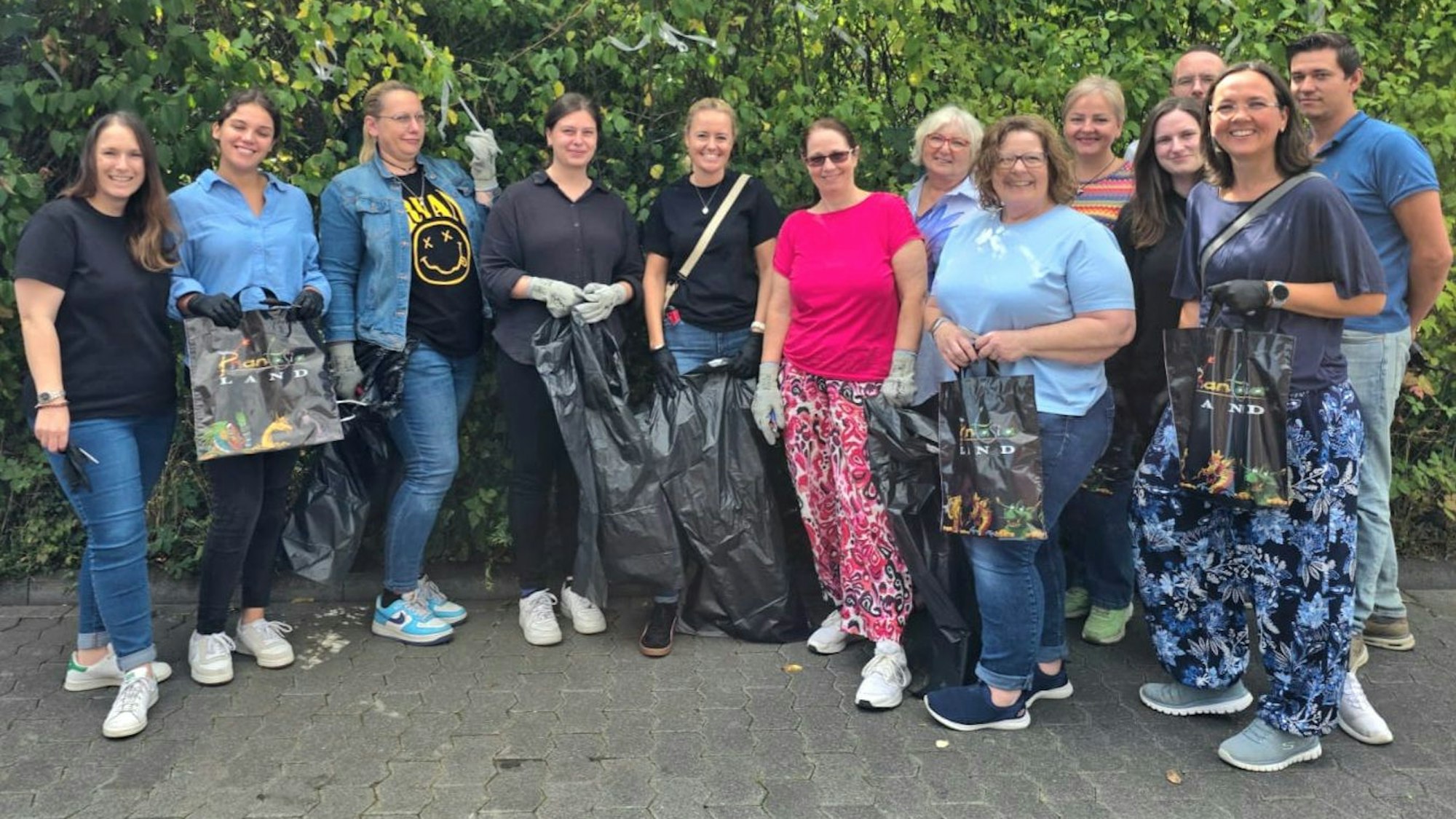 Zu sehen sind Menschen, die zum Teil Müllsäcke halten.