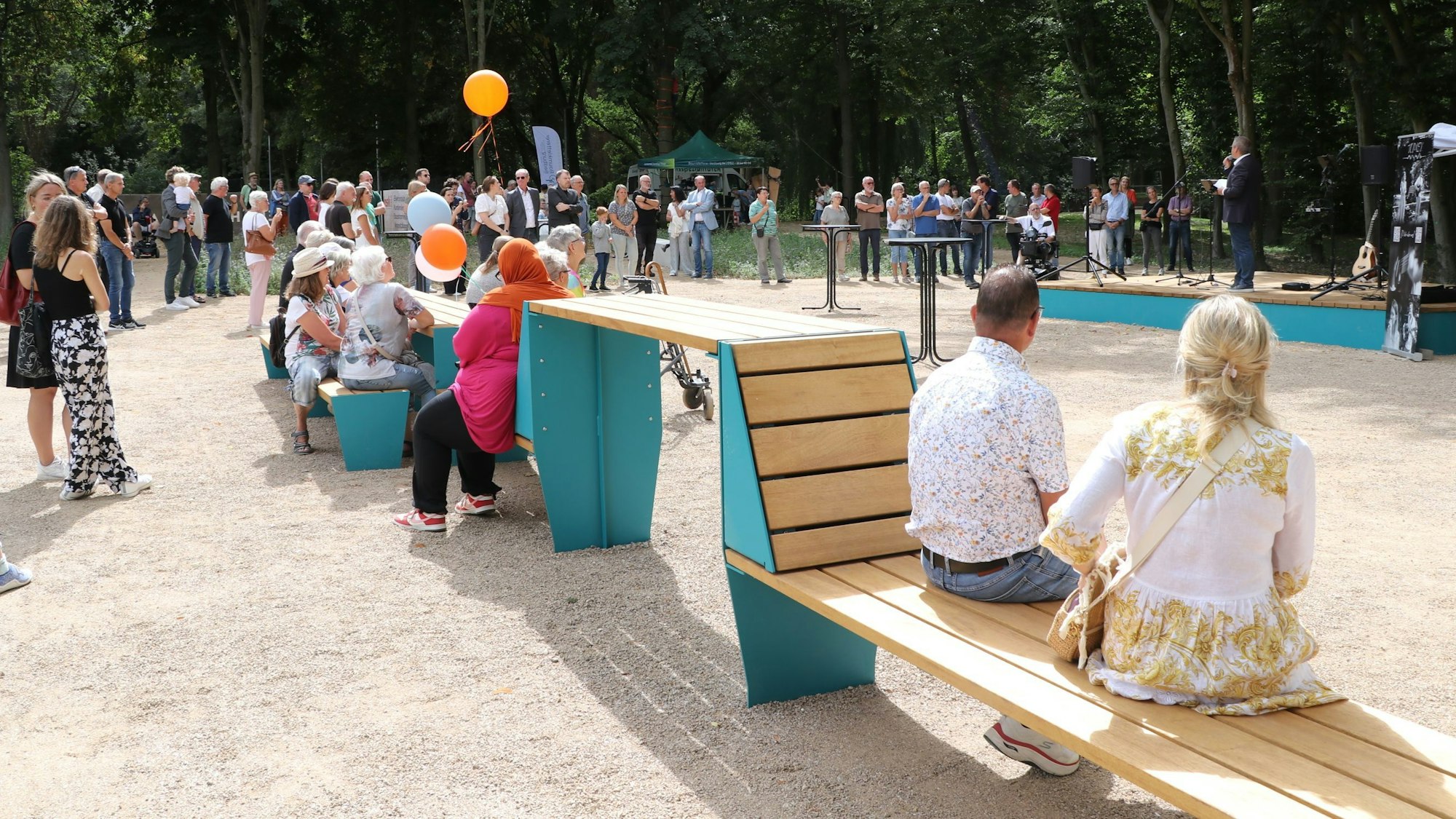 Zu sehen sind Menschen bei einer Feier in einem Park.