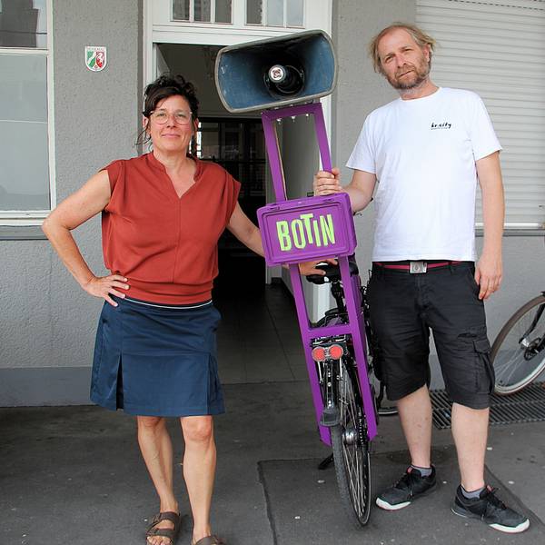 Eine Frau und ein Mann stehen nebeneinander, zwischen ihnen ein Fahrrad mit einem ungewöhnlichen Gepäckträger.