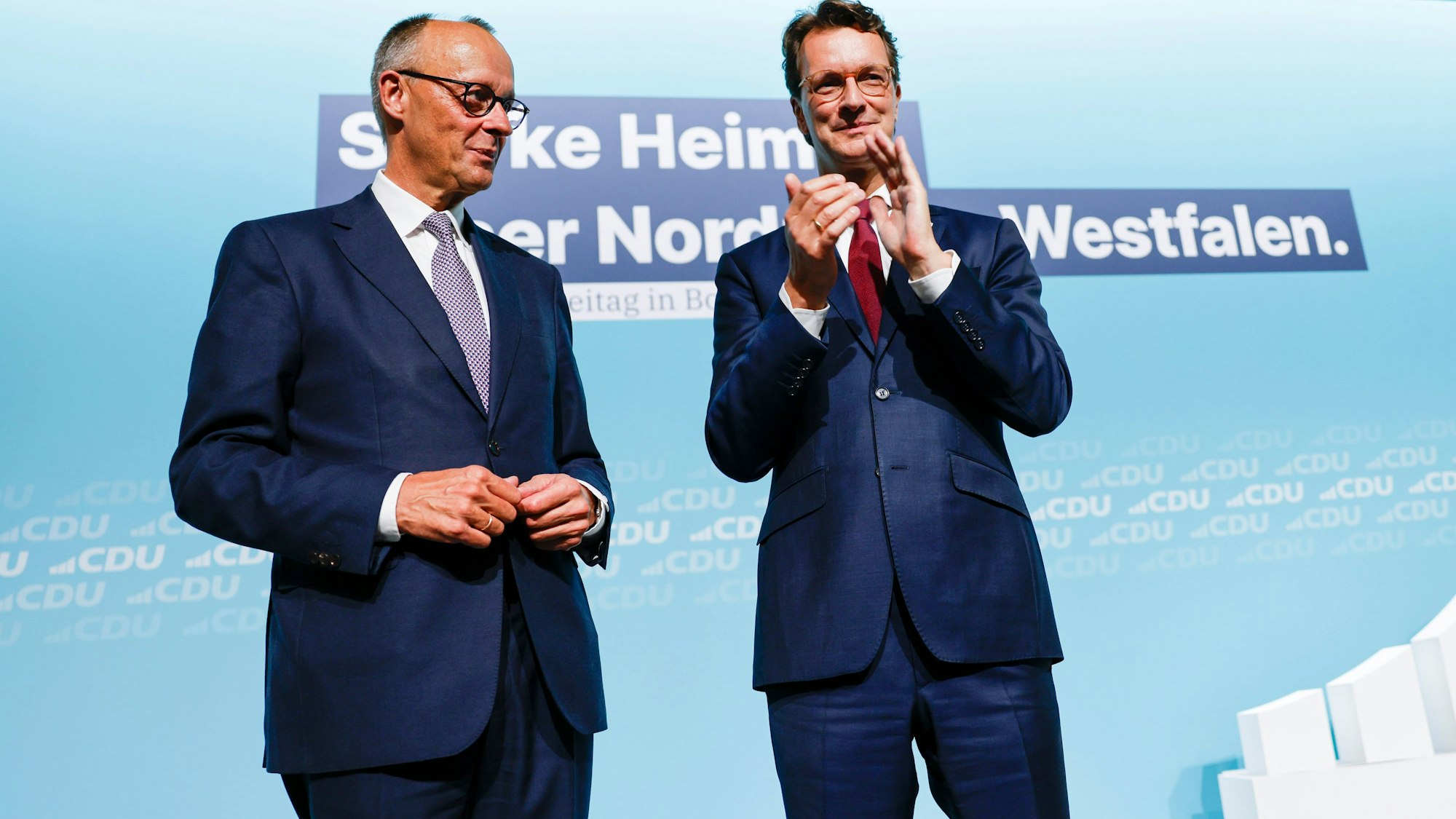 Bonn: Bundeskanzler Friedrich Merz (l, CDU) steht nach seiner Rede beim Landesparteitag der CDU Nordrhein-Westfalen mit Hendrik Wüst (CDU), Ministerpräsident von Nordrhein-Westfalen, auf der Bühne.