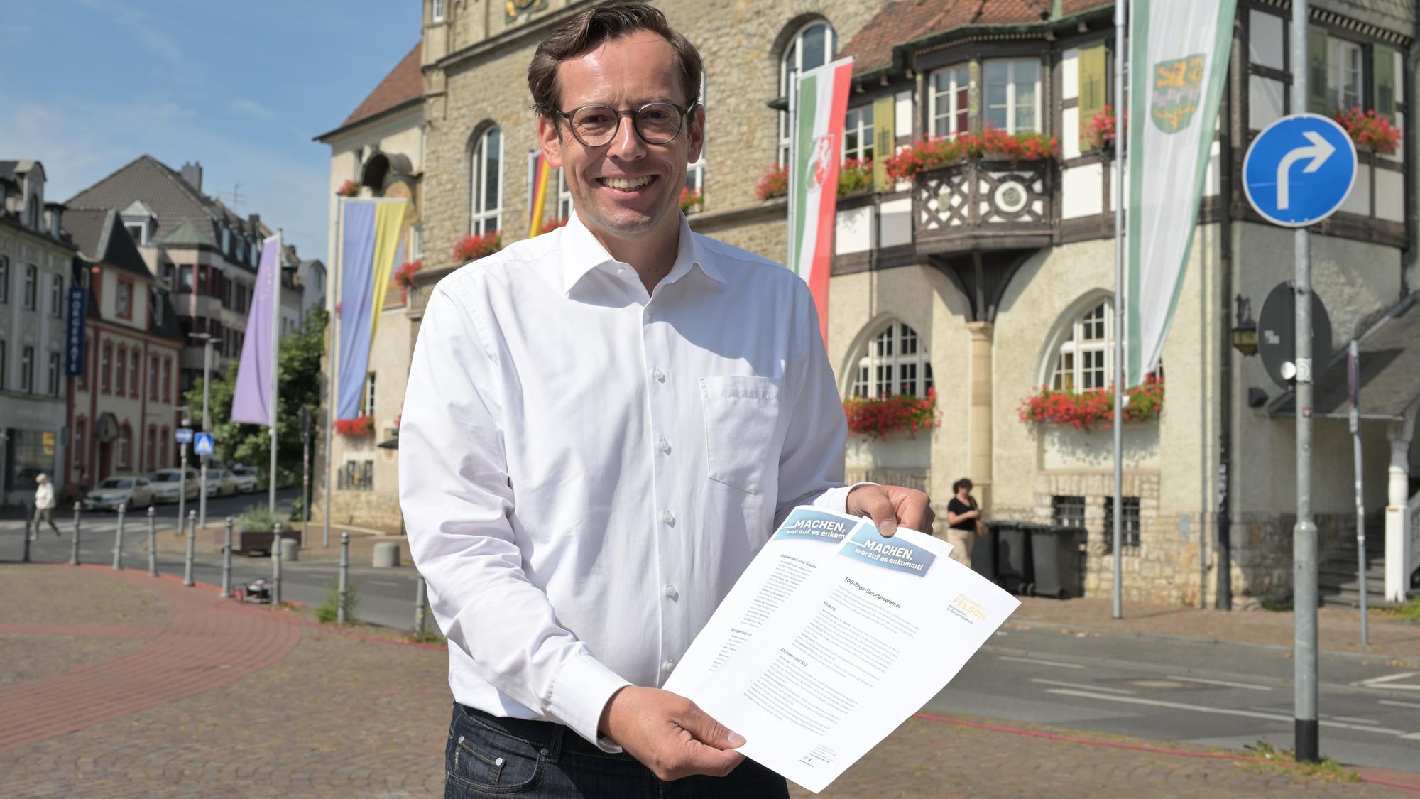Alexander Felsch, der Bürgermeisterkandidat von CDU und FDP, mit seinem 100-Tage-Sofortprogramm vor dem Bergisch Gladbacher Rathaus.