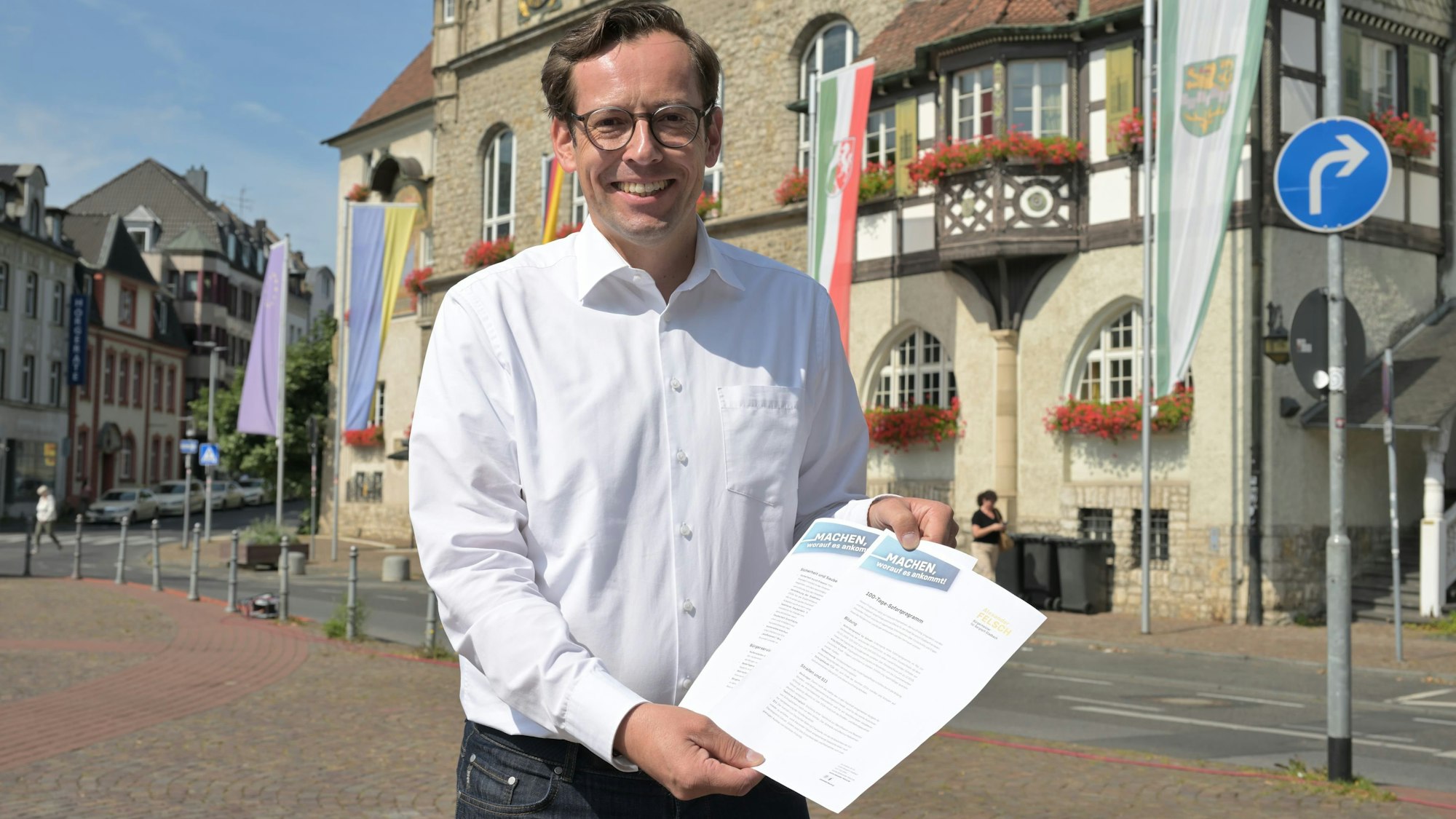 Alexander Felsch, der Bürgermeisterkandidat von CDU und FDP, mit seinem 100-Tage-Sofortprogramm vor dem Bergisch Gladbacher Rathaus.