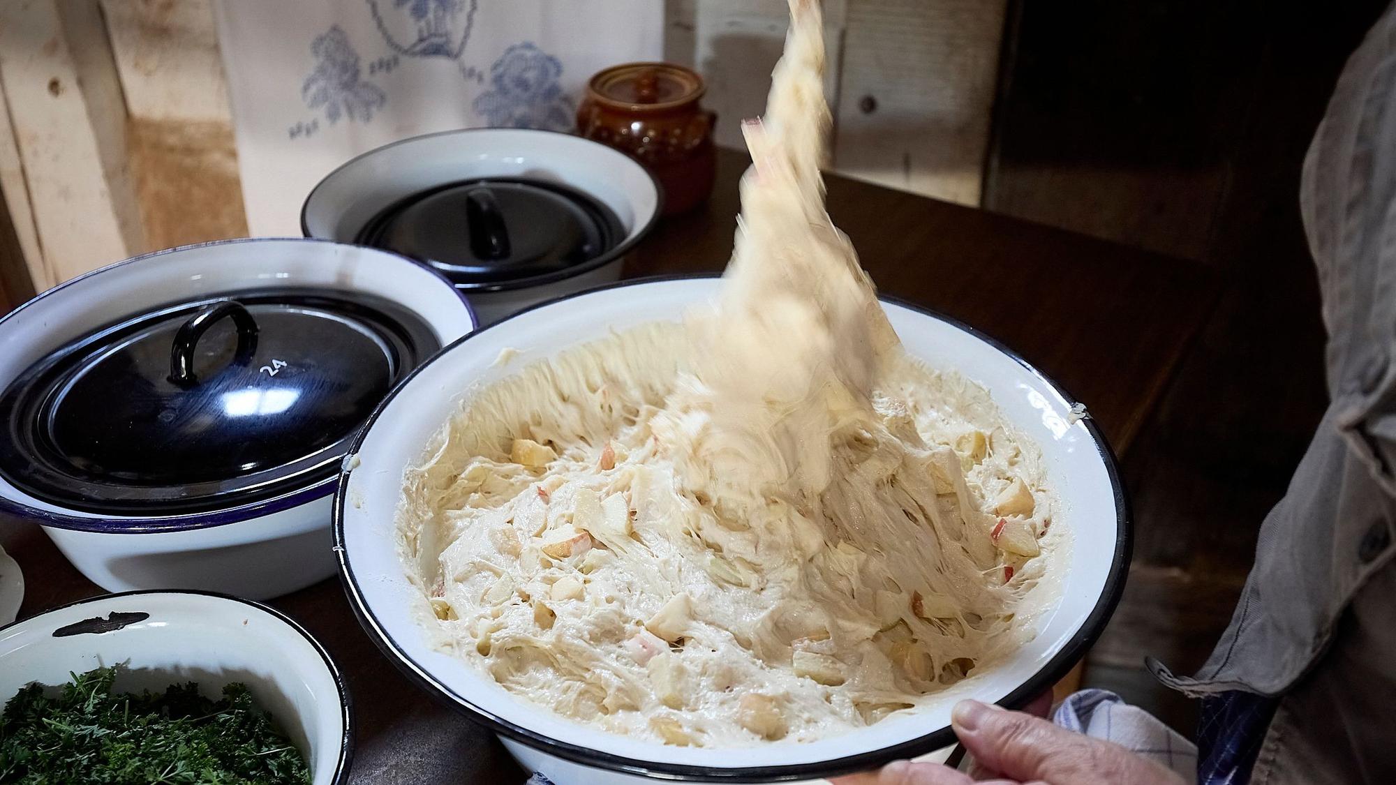 Pfannkuchenteig wird an einem Löffel aus einer Schüssel gezogen.