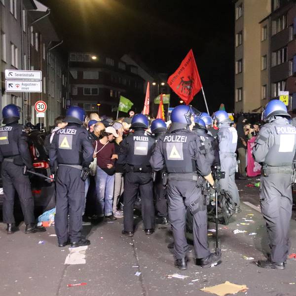 Polizeikräfte stehen Teilnehmenden einer Demo gegenüber.
