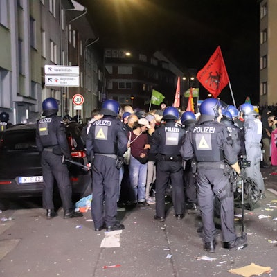 Polizeikräfte stehen Teilnehmenden einer Demo gegenüber.