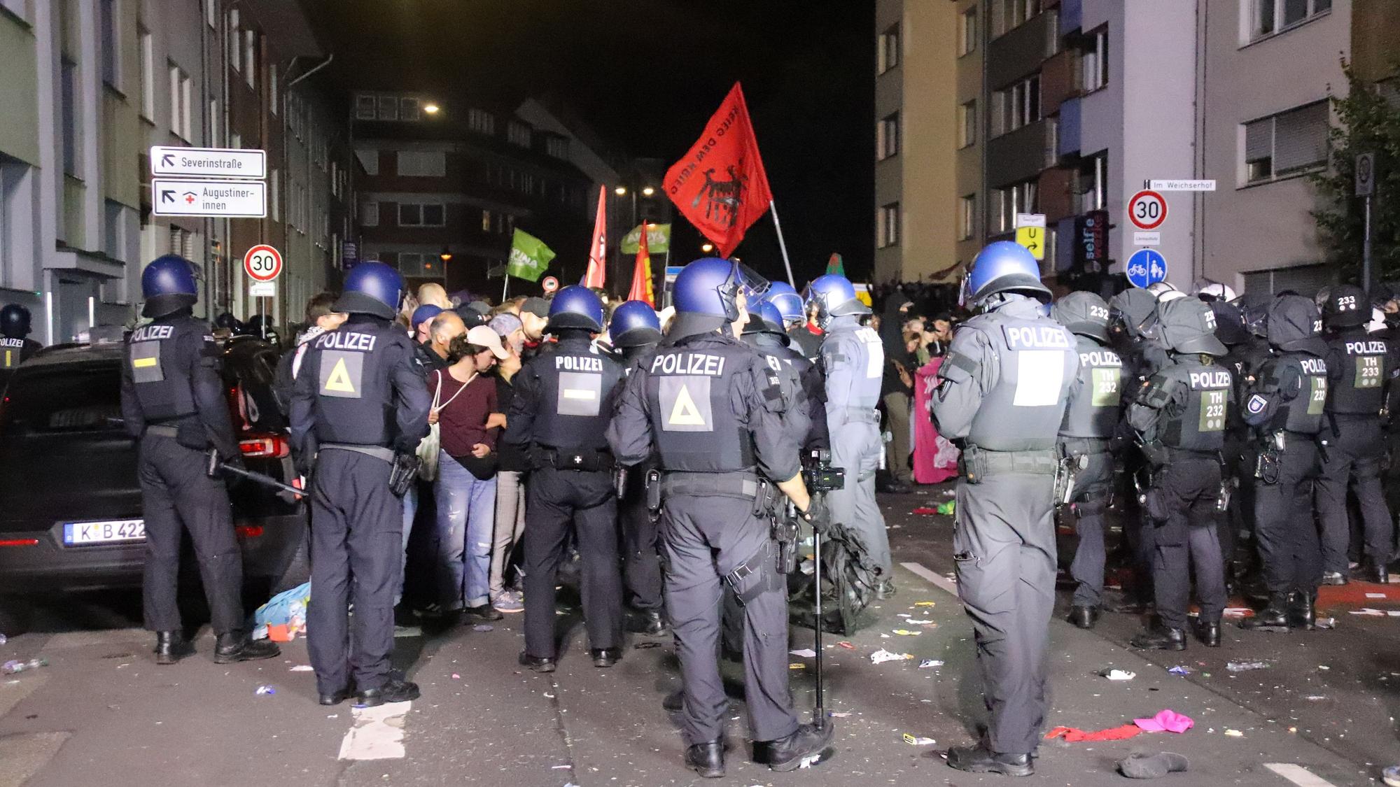 Polizeikräfte stehen Teilnehmenden einer Demo gegenüber.