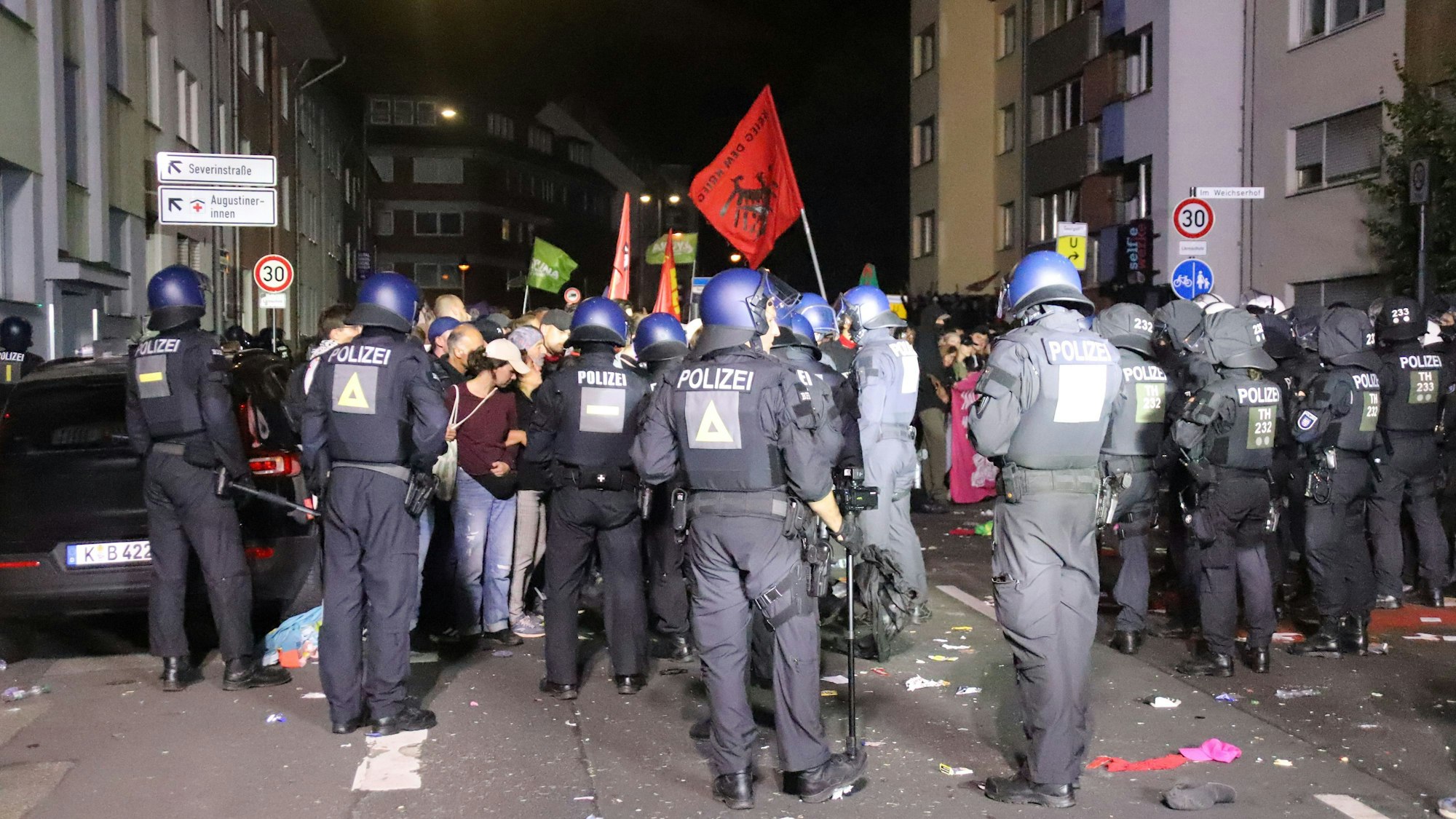 Polizeikräfte stehen Teilnehmenden einer Demo gegenüber.