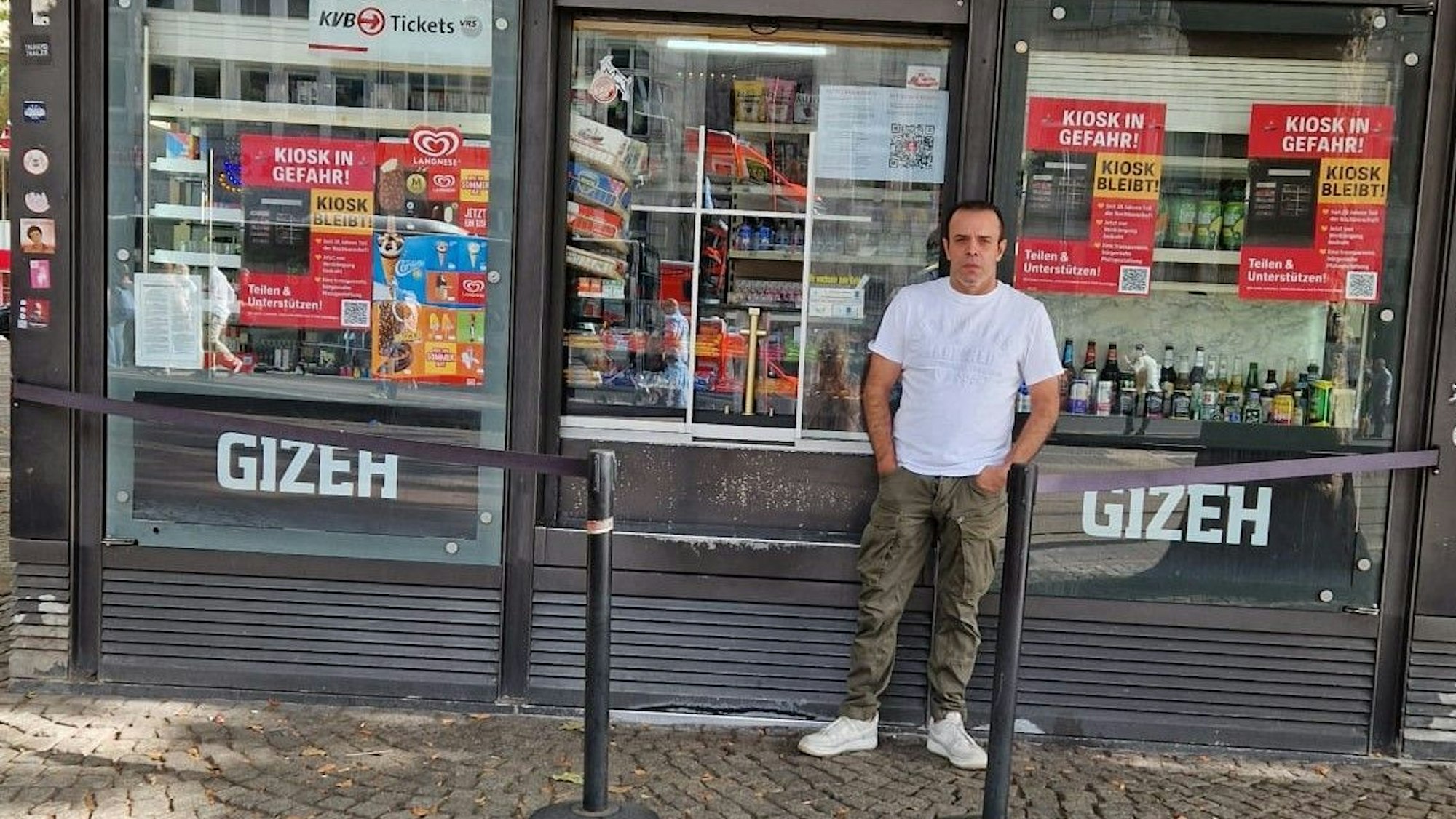 Ein Mann steht vor einem Kiosk.