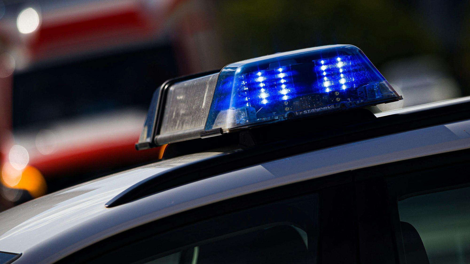 Das Blaulicht eines Einsatzfahrzeugs leuchtet an einer Einsatzstelle.