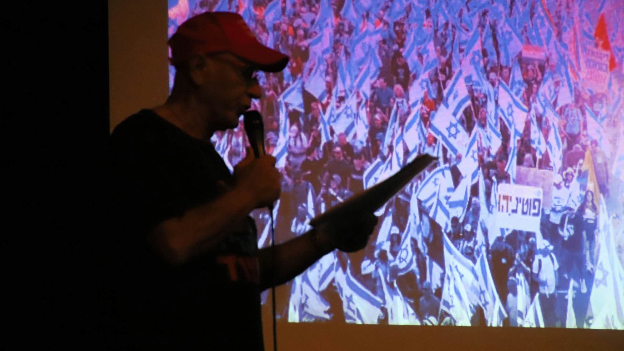 Der Schattenriss eines Menschen vor einem Foto mit vielen israelischen Fahnen.