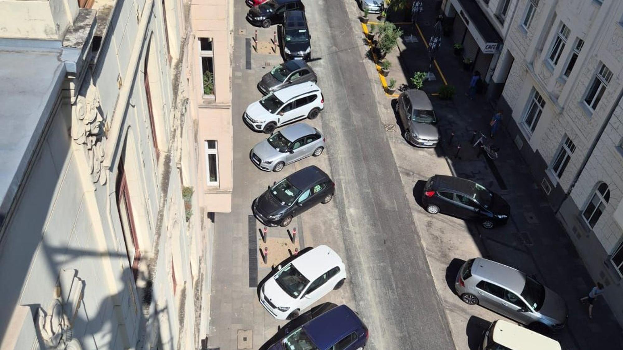 Quer zur Fahrbahn geparkte Autos mit Strafzetteln an der Windschutzscheibe in einer Kölner Straße.