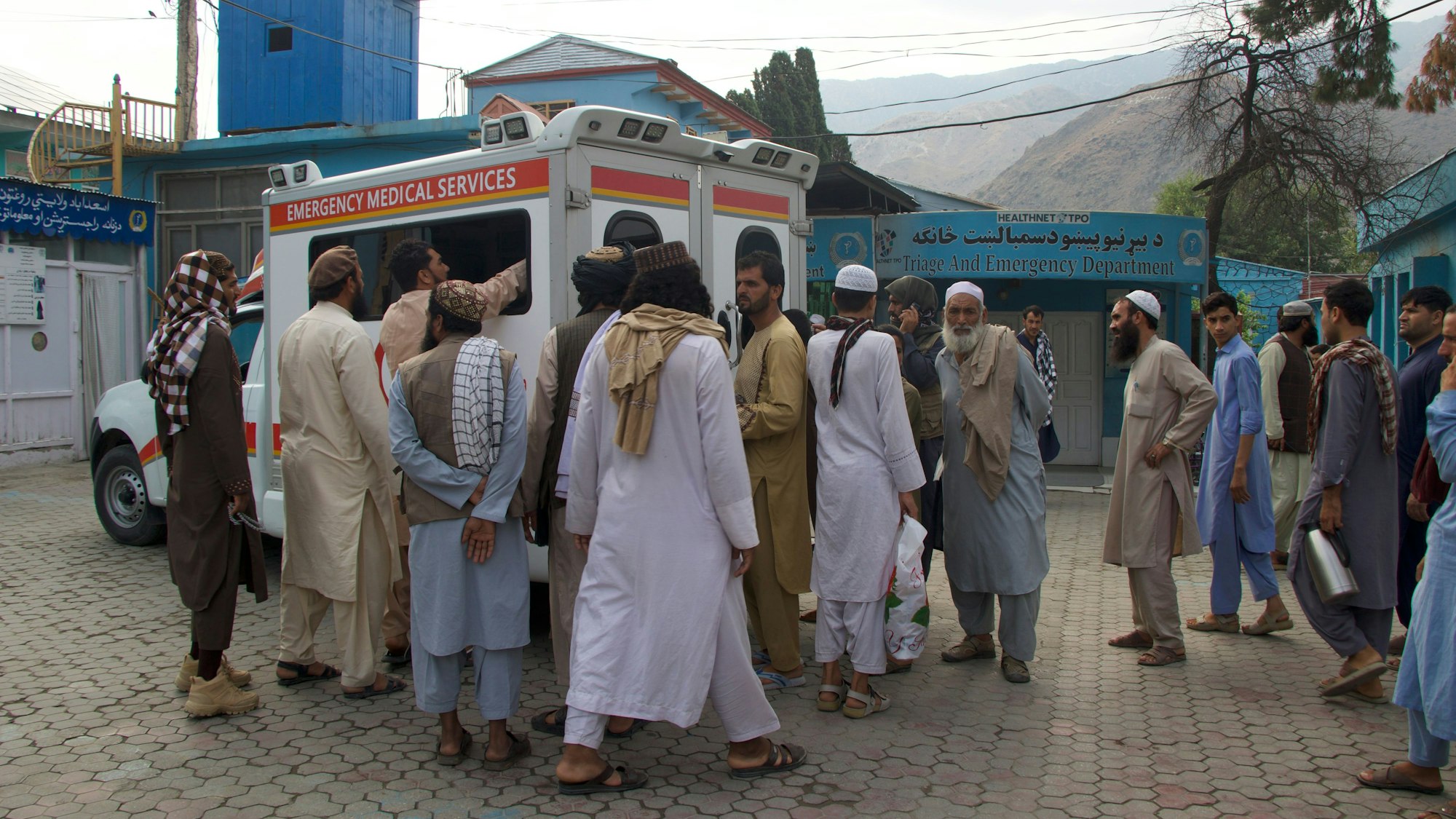 Menschen versammeln sich in der Nähe eines Krankenwagens in einem Krankenhaus in der Provinz Kunar.