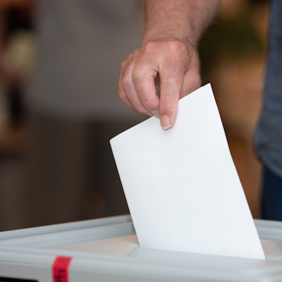 Ein Wähler wirft in einem Wahllokal seinen Stimmzettel in die Wahlurne.