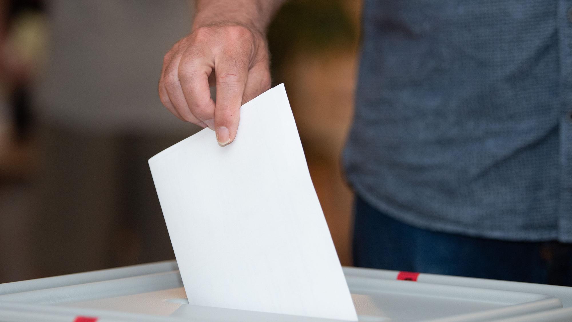 Ein Wähler wirft in einem Wahllokal seinen Stimmzettel in die Wahlurne.