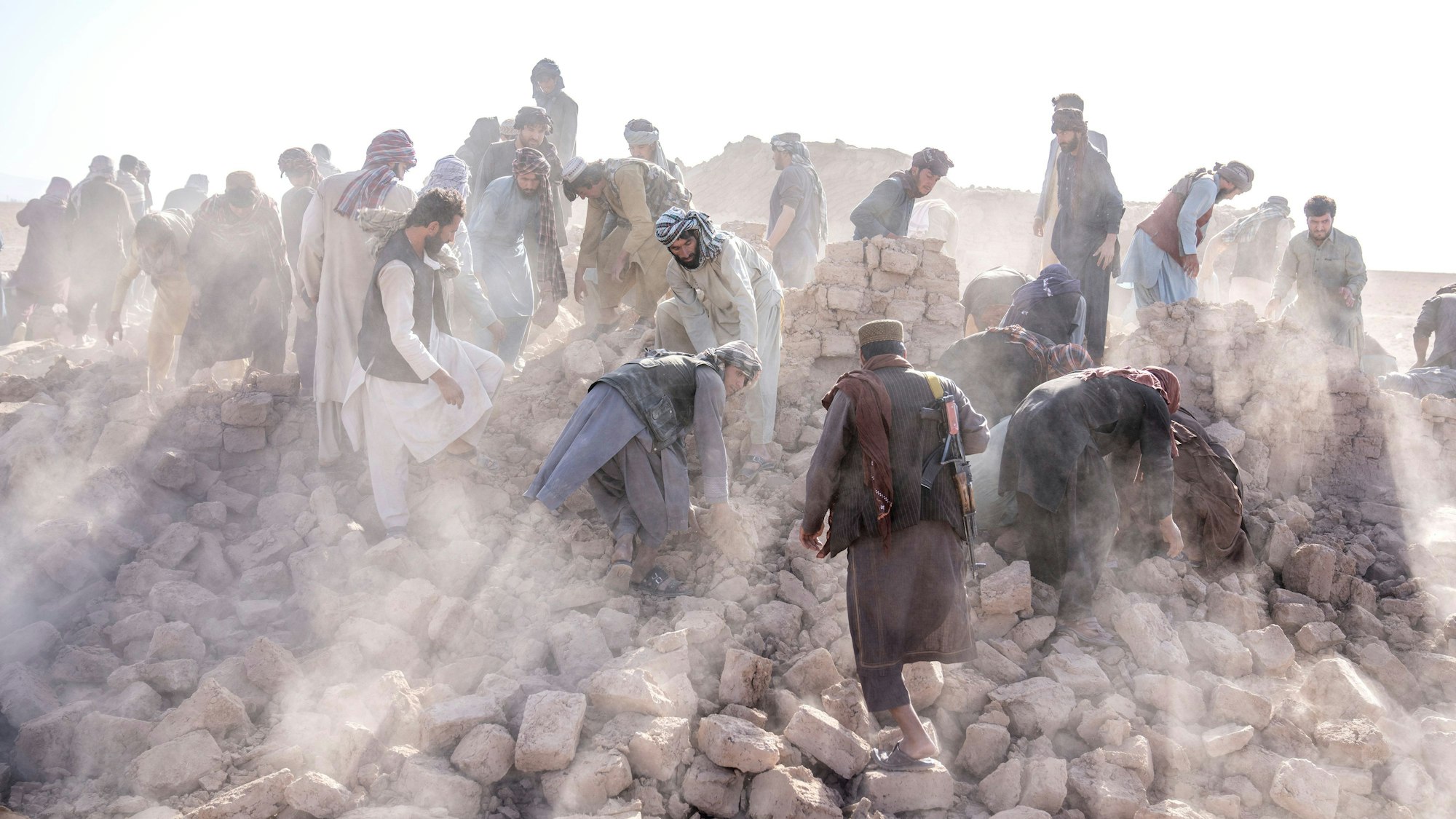 ARCHIV - 10.10.2023, Afghanistan, Herat: Freiwillige arbeitet in den Trümmern nach einem Erdbeben im Bezirk Zenda Jan. Ein weiteres starkes Erdbeben erschütterte den Westen Afghanistans. (zu dpa: «Staatsagentur: Rund 250 Tote bei Erdbeben in Afghanistan») Foto: Ebrahim Noroozi/AP/dpa +++ dpa-Bildfunk +++