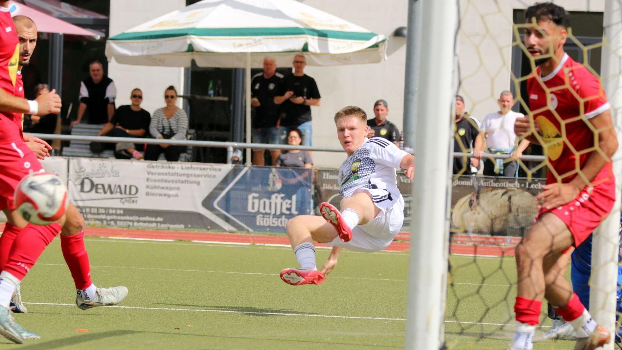 Ein Spieler von Erftstadt-Lechenich liegt quer in der Luft.