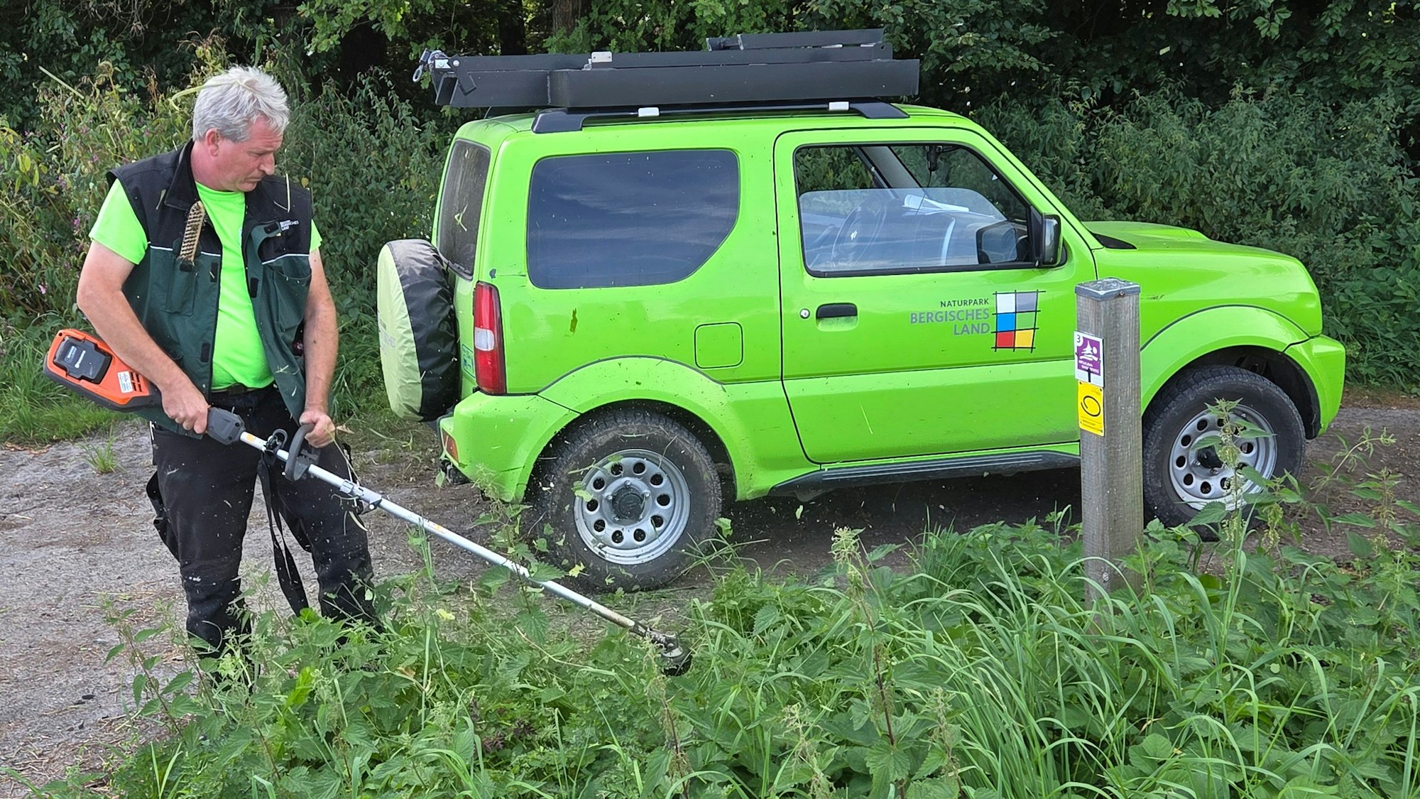 Am Blockhaus-Parkplatz bei Reichshof-Tillkausen wirft Wanderwegemanager Wastl Roth-Seefrid den Freischneider an, um den Zugang zum Bergischen Panoramasteig eindeutig erkennbar zu machen.