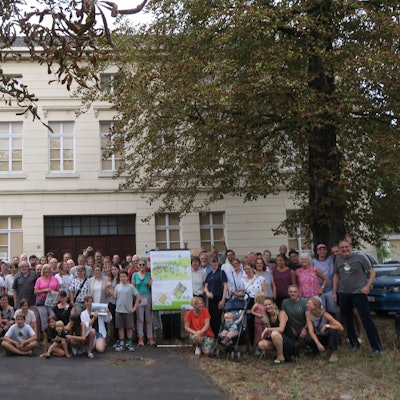 Ein große Gruppe Menschen hat sich vor dem ehemaligen Hauptgebäude des Lindweiler Hofs an der Rochusstraße versammelt.