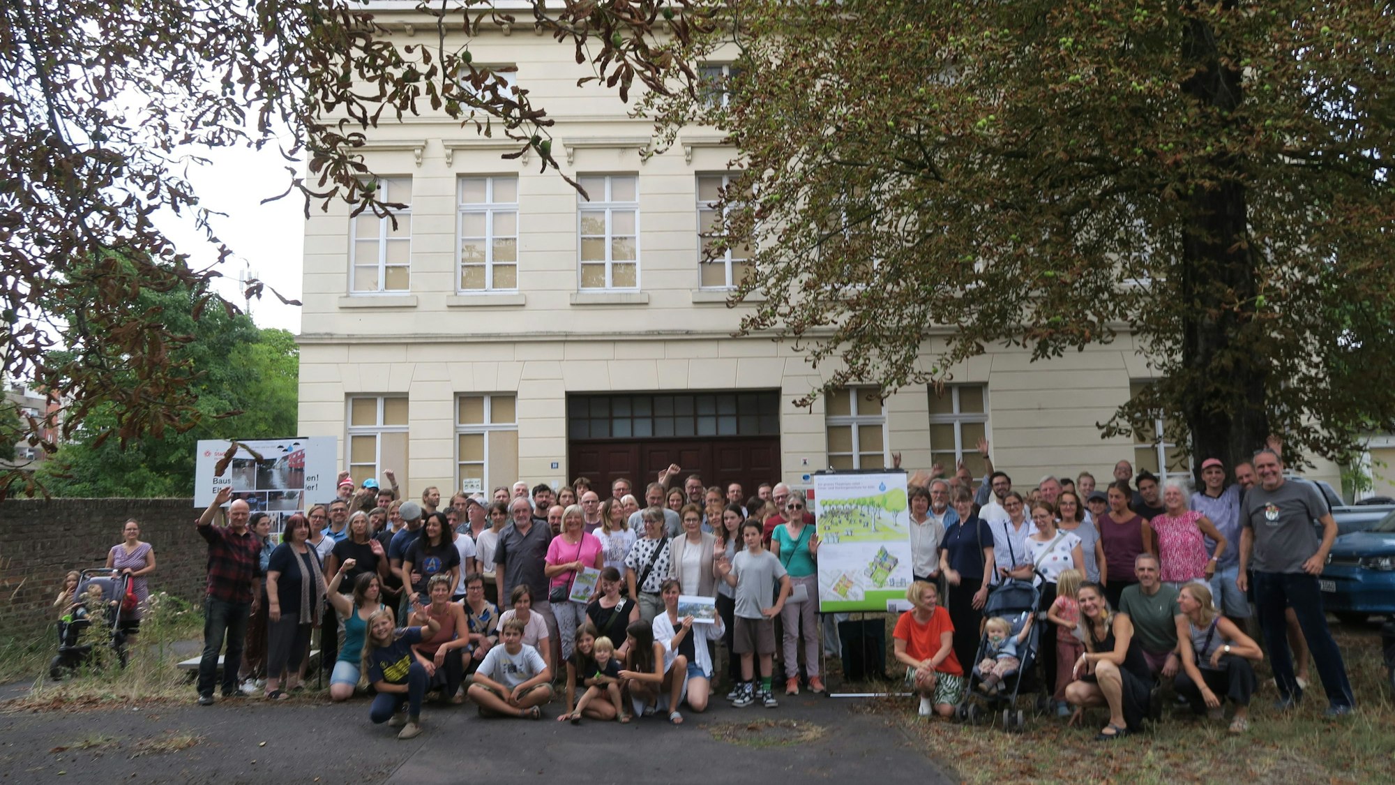 Ein große Gruppe Menschen hat sich vor dem ehemaligen Hauptgebäude des Lindweiler Hofs an der Rochusstraße versammelt.