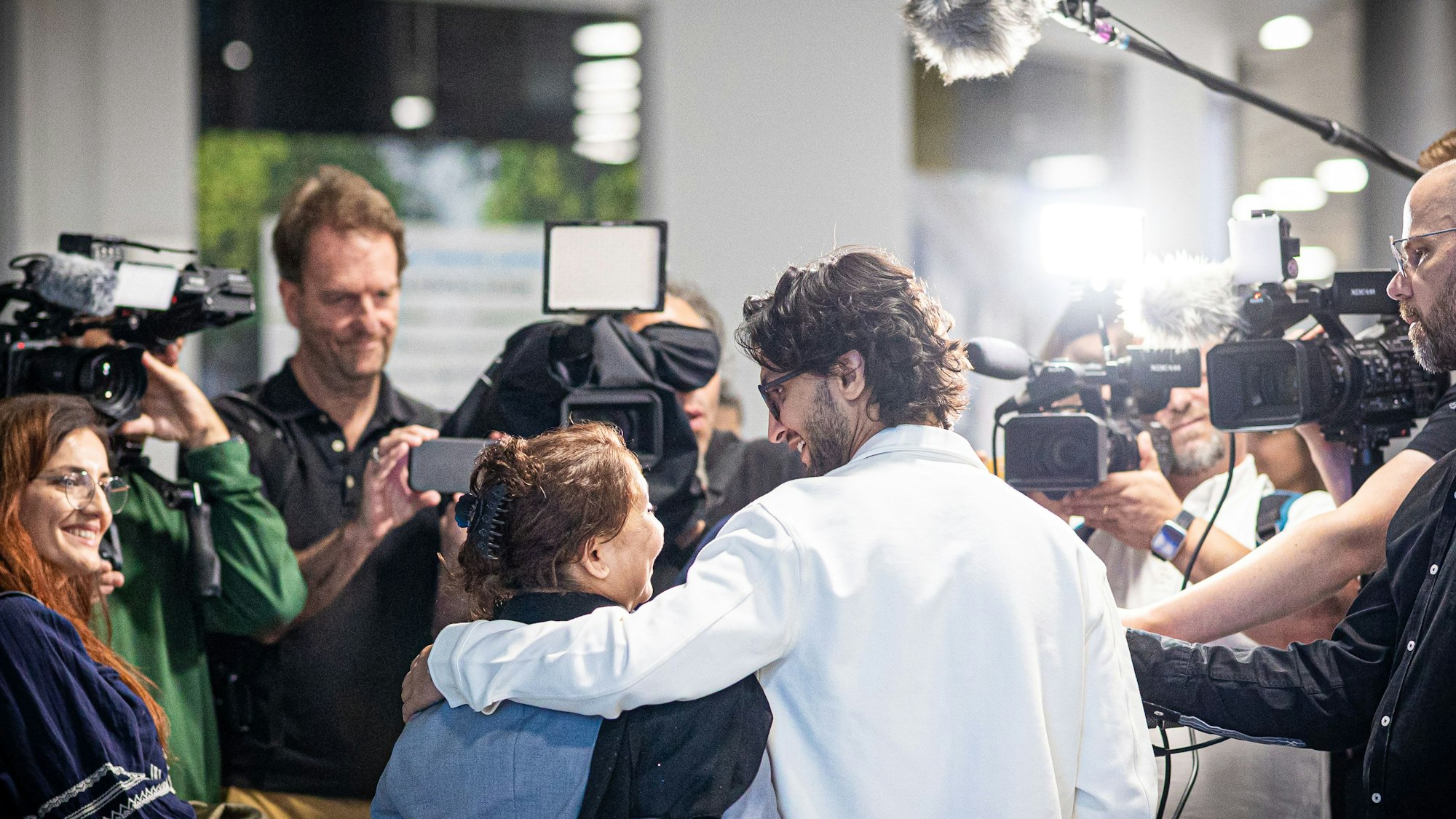 dpatopbilder - 01.09.2025, Niedersachsen, Langenhagen: Menschen aus Afghanistan, die zuvor mit einem Flugzeug auf dem Flughafen Hannover-Langenhagen gelandet sind, spechen zu Pressevertretern. Nach monatelanger Wartezeit sind mehrere Familien mit Aufnahmezusage in Deutschland angekommen. Foto: Moritz Frankenberg/dpa +++ dpa-Bildfunk +++