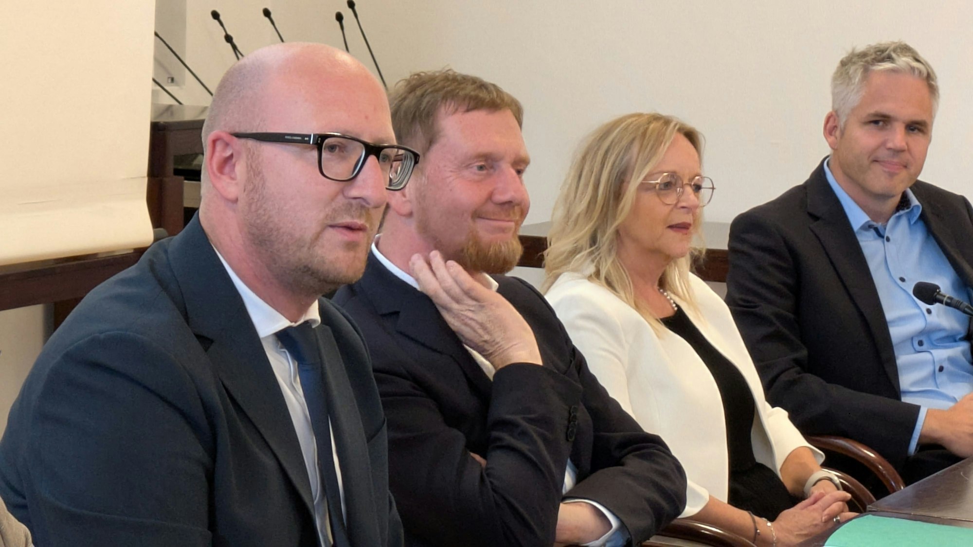 Ingo Pfennings, Michael Kretschmer, Sabine Preiser-Marian und Ronny Großer sitzen an einem Tisch.
