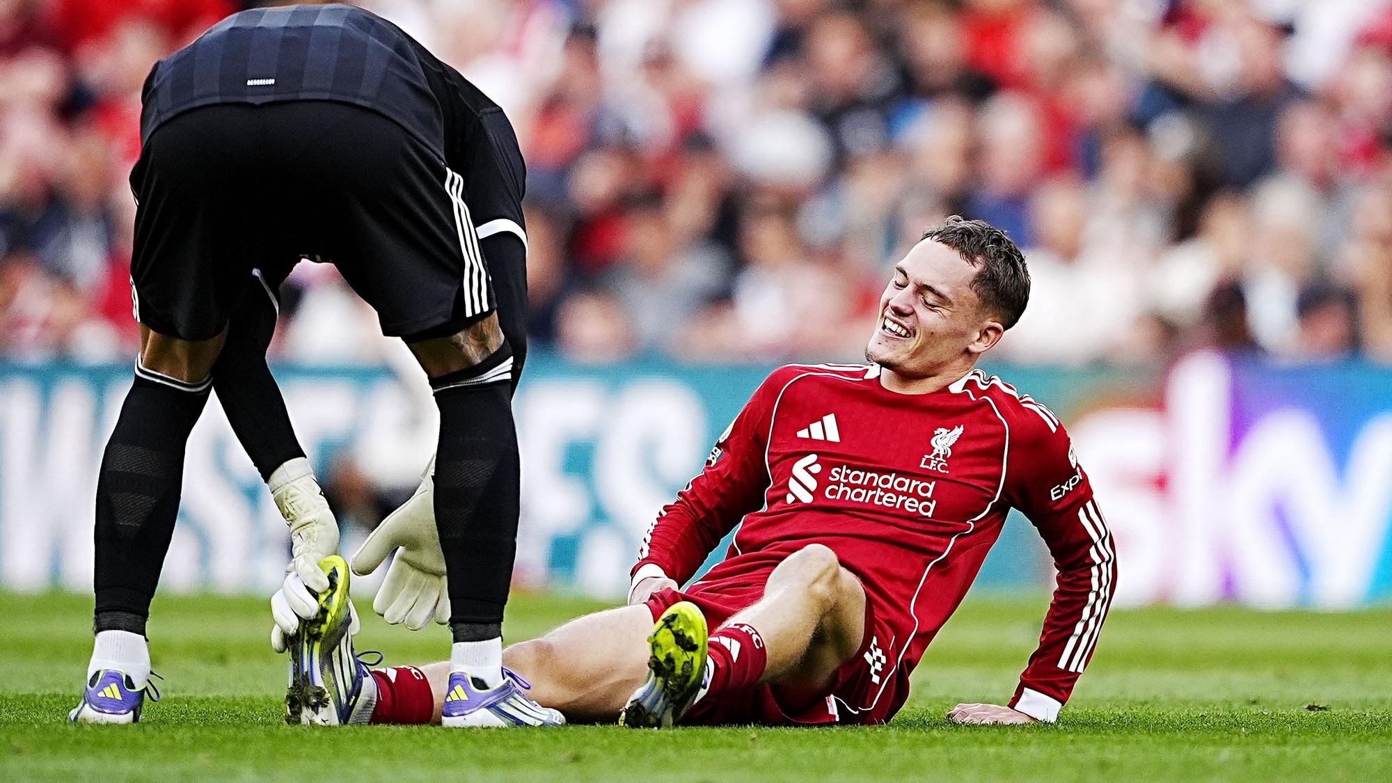 Arsenals Torhüter David Raya hilft Liverpools Florian Wirtz bei Krämpfen während des Premier-League-Spiels in Anfield.