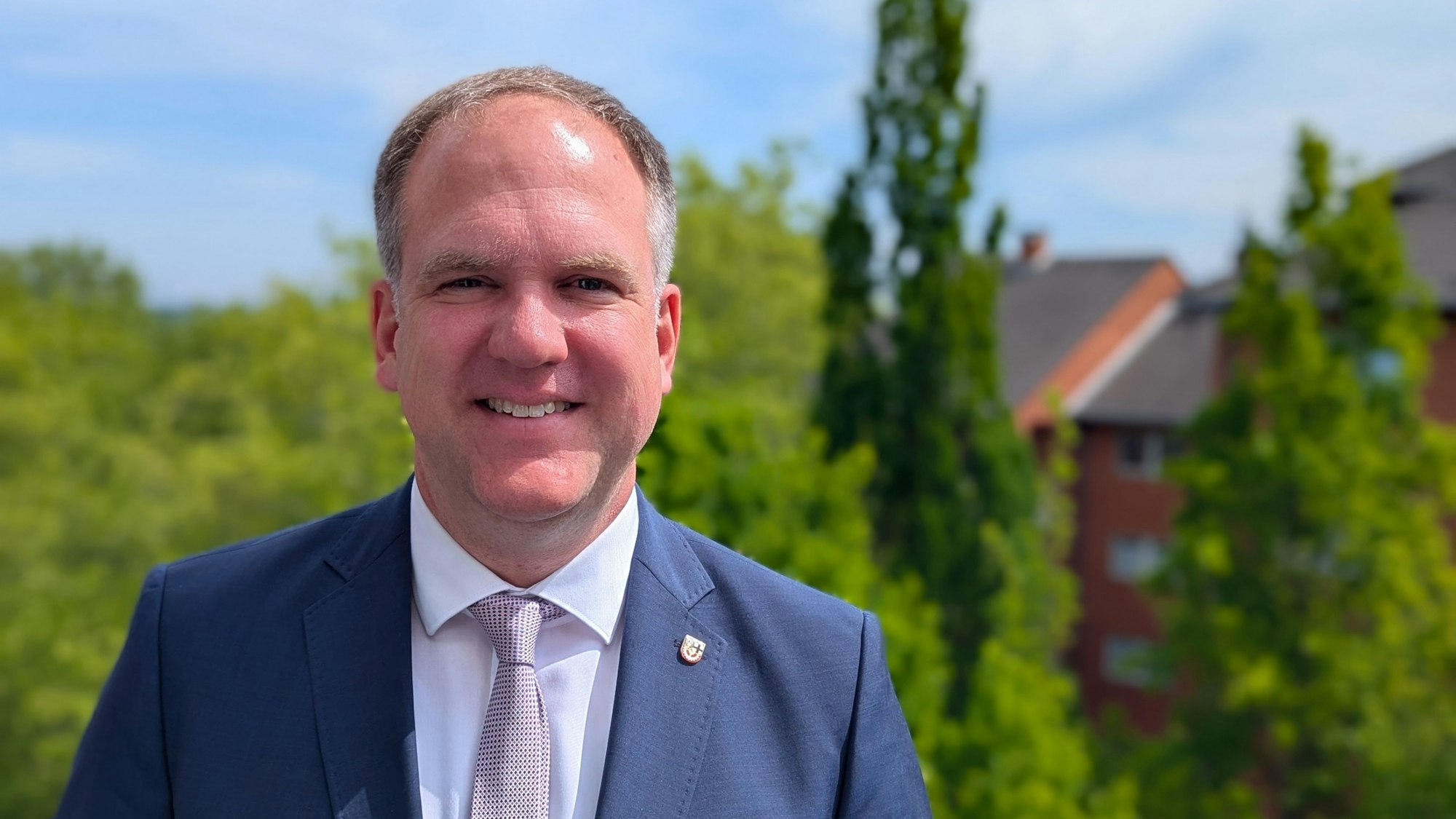 Das Foto zeigt Bürgermeister Dirk Breuer auf dem Balkon seines Büros im Rathaus.