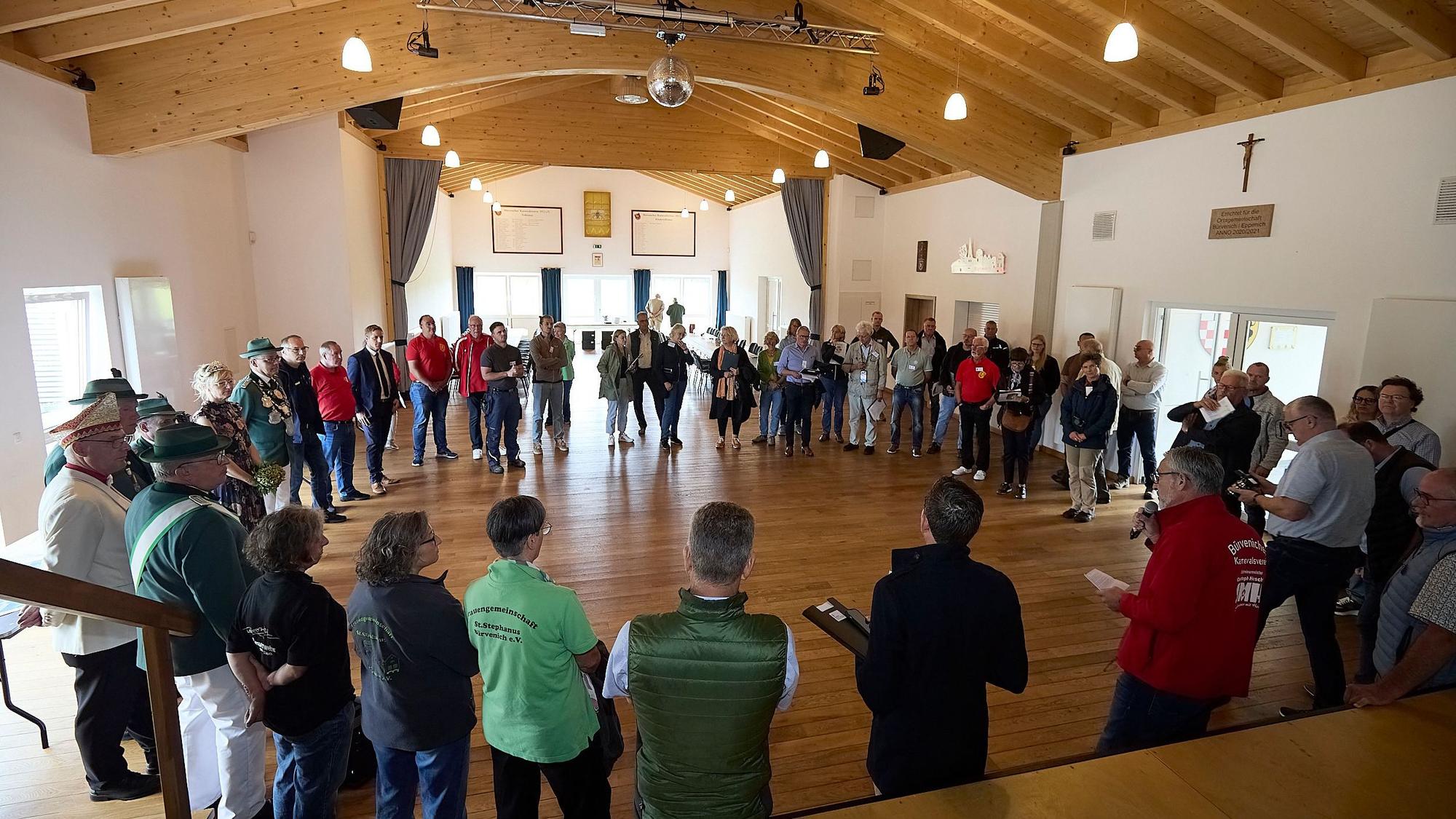 Zahlreiche Menschen stehen im Dorfgemeinschaftshaus in Zülpich-Bürvenich im Kreis.