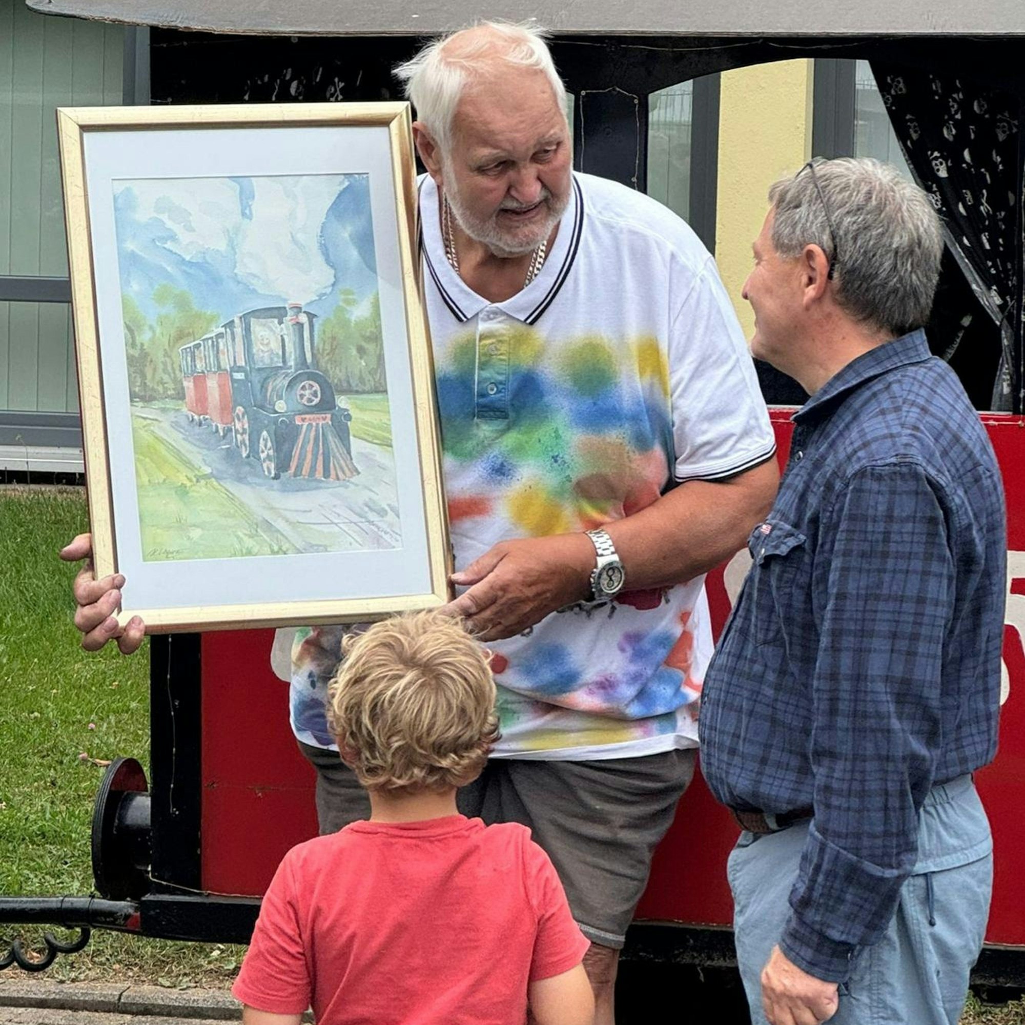 Ein Aquarellbild bekommt Jürgen Kalina von Henry Schellenberg überreicht.