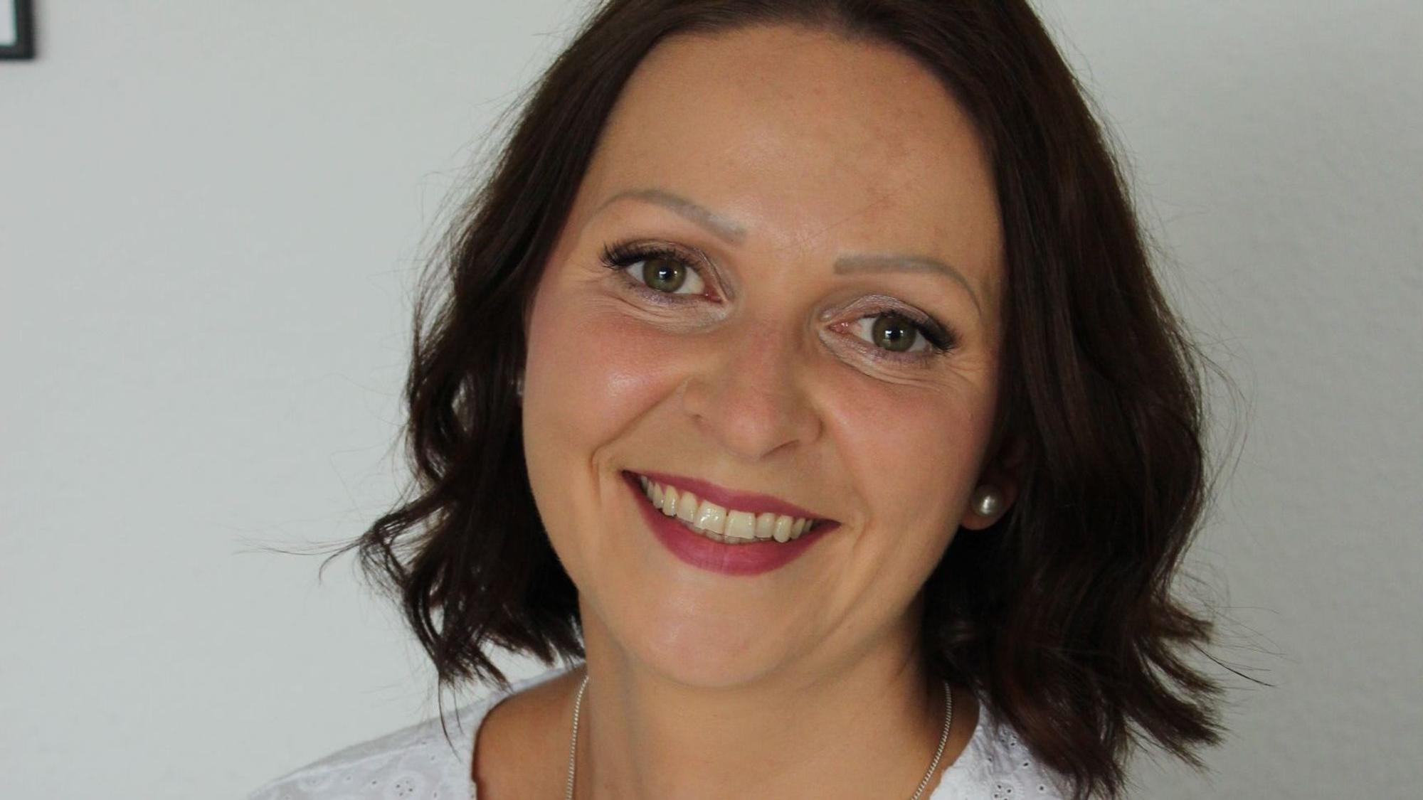 Auf dem Bild ist das Portrait einer Frau mit braunen Haaren und Augen zu sehen.
