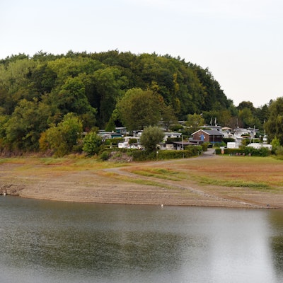 Das Foto zeigt den Campingplatz Käfernberg, im Vordergrund die Bevertalsperre, die derzeit viel zu wenig Wasser führt.