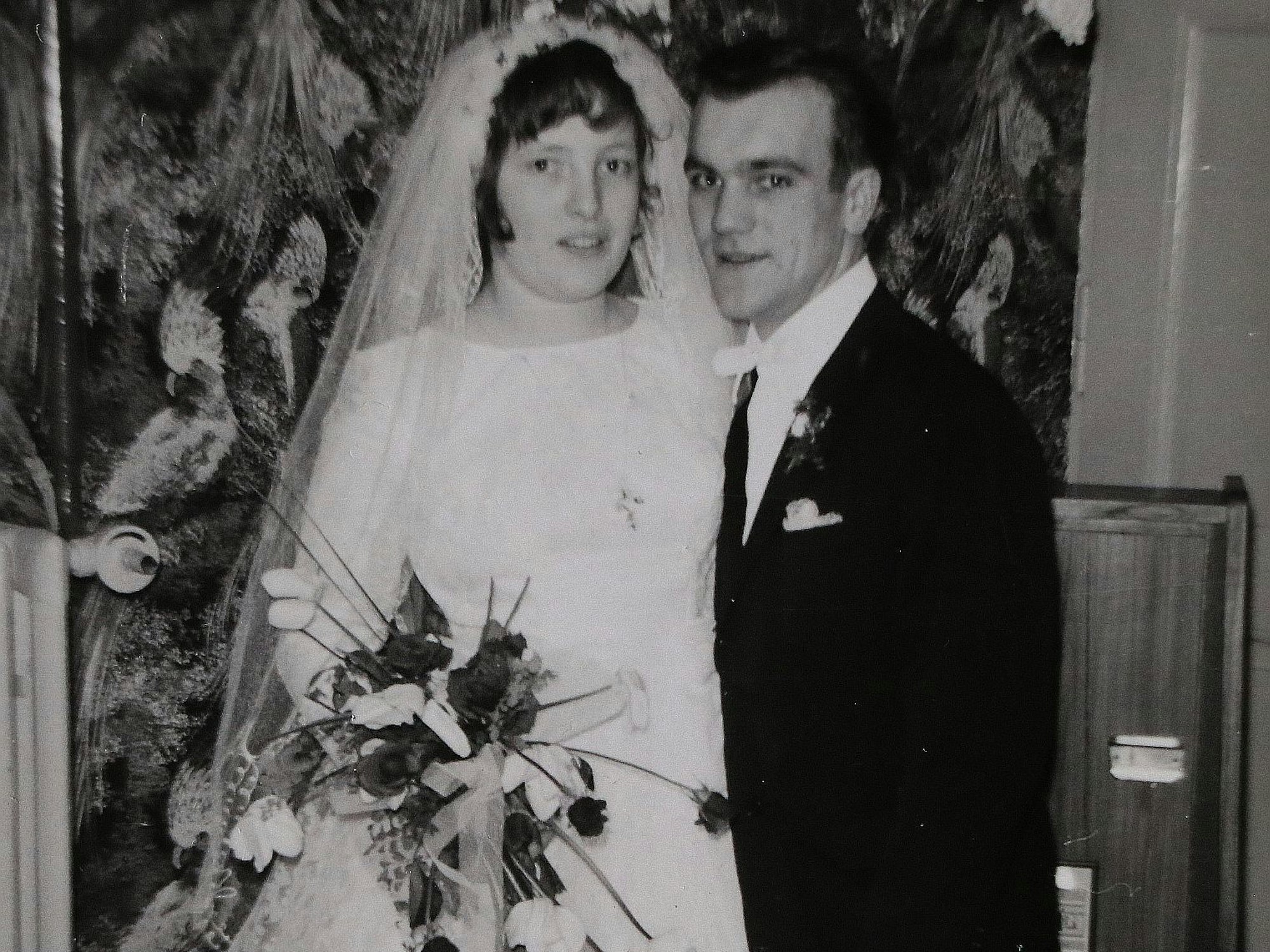 Auf dem Bild ist eine Schwarz-Weiß-Aufnahme des Ehepaars bei seiner Hochzeit zu sehen.