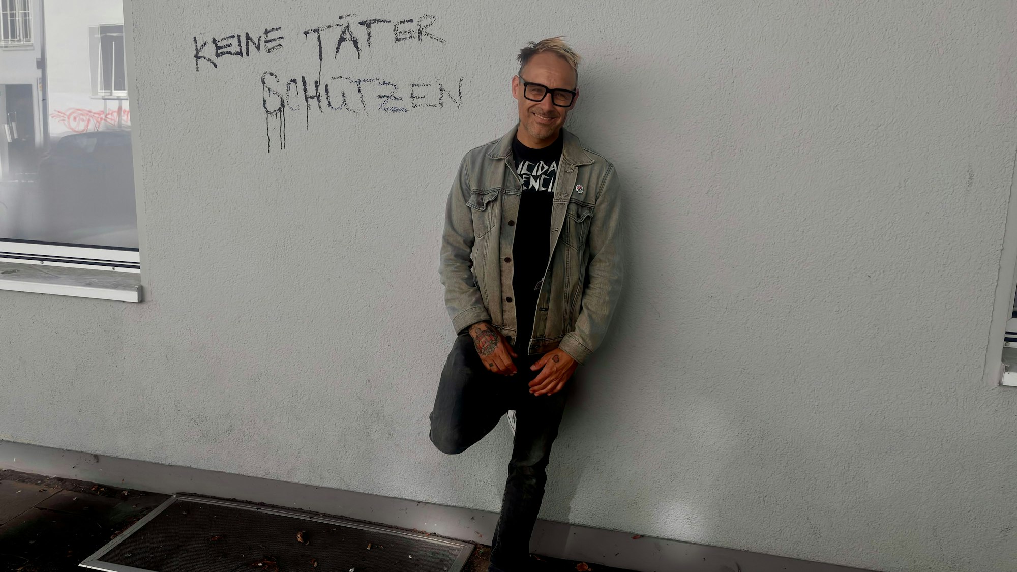 Das Bild zeigt Ingo Knollmann, Sänger der Donots, wie er in Münster an einer Hauswand lehnt. Foto: Kevin Goonewardena