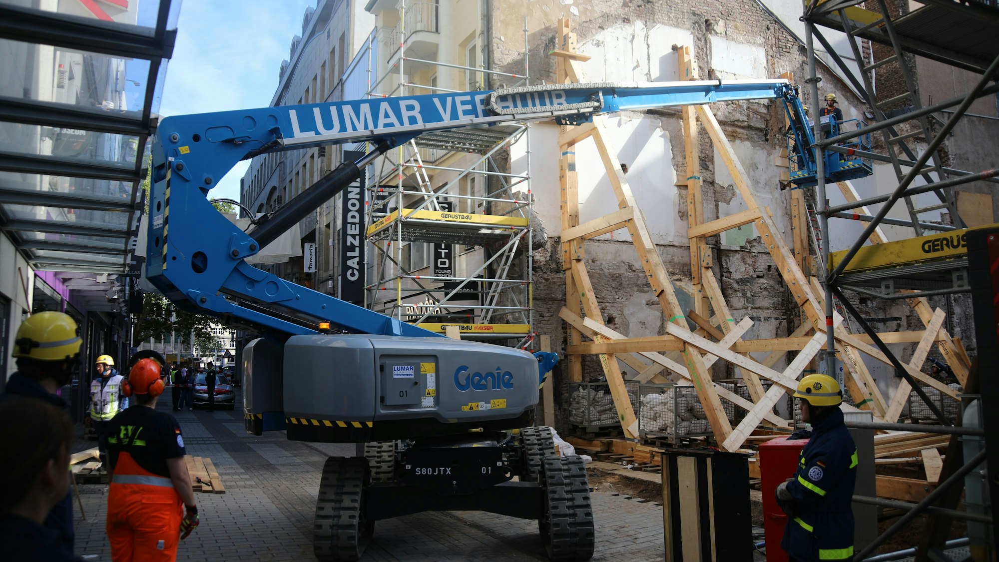 Einsatzkräfte des THW arbeiten am Stützsystem an einem Haus.