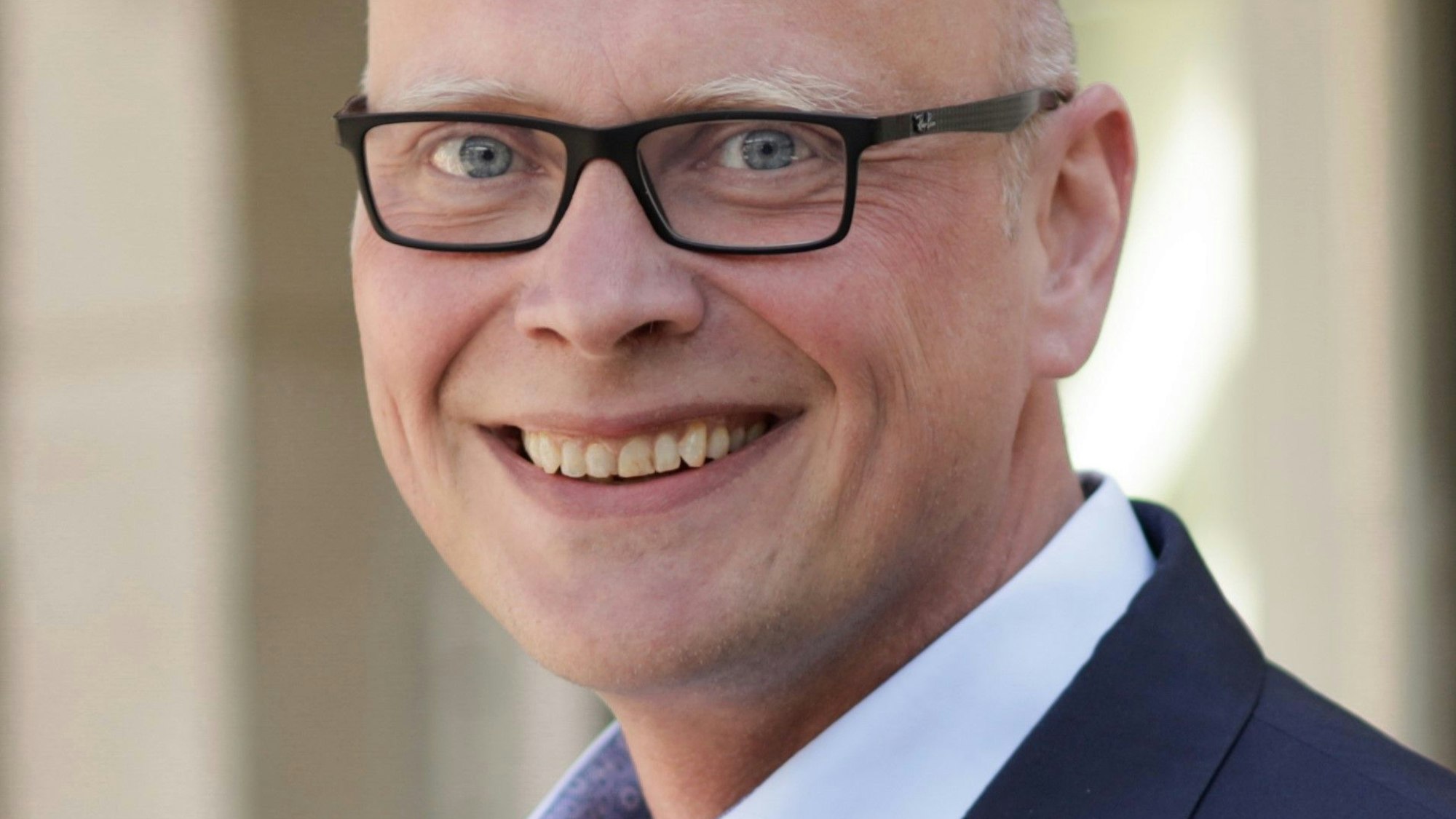 Sebastian Glatzel trägt Sakko und Hemd.