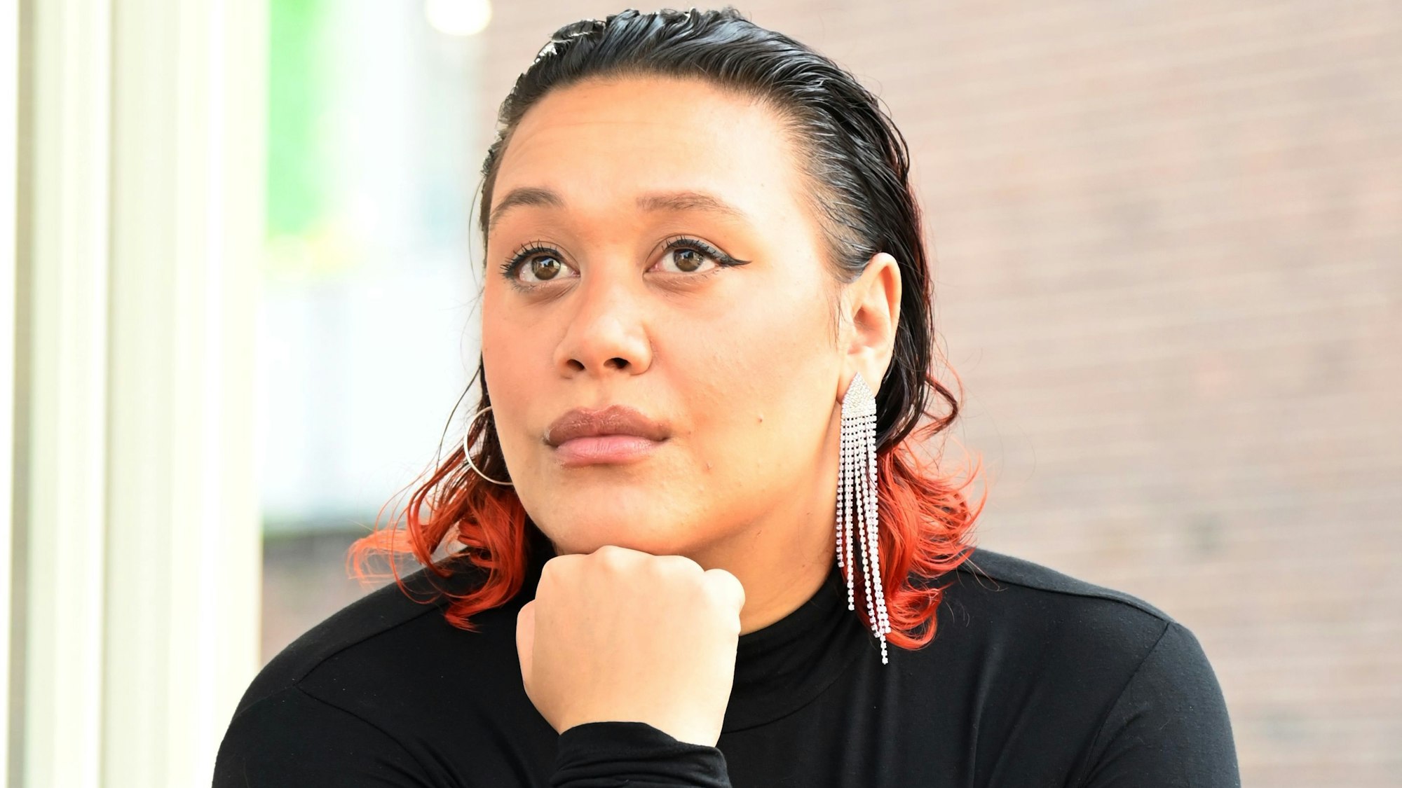 Ray Lozano stützt ihren Kopf auf ihre Faust.