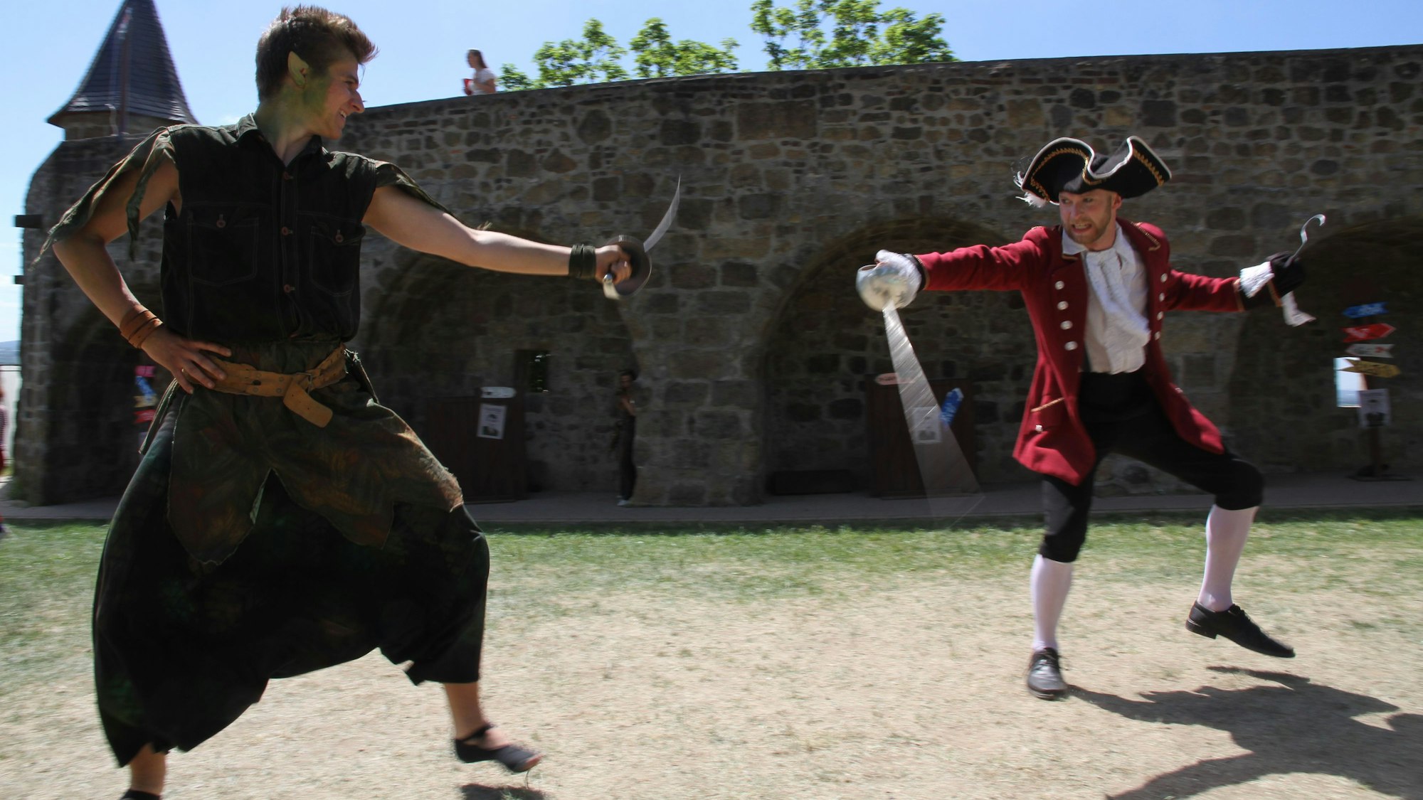 Peter Pan und Captain Hook erheben die Schwerter gegeneinander.