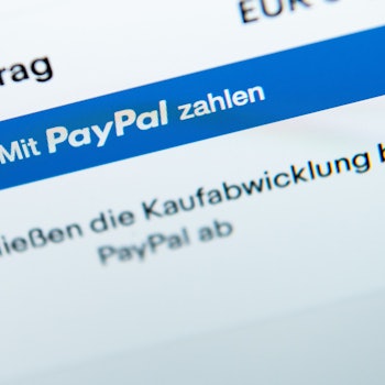 Der Schriftzug «Mit Paypal zahlen» ist auf dem Bildschirm eines Laptops zu sehen.