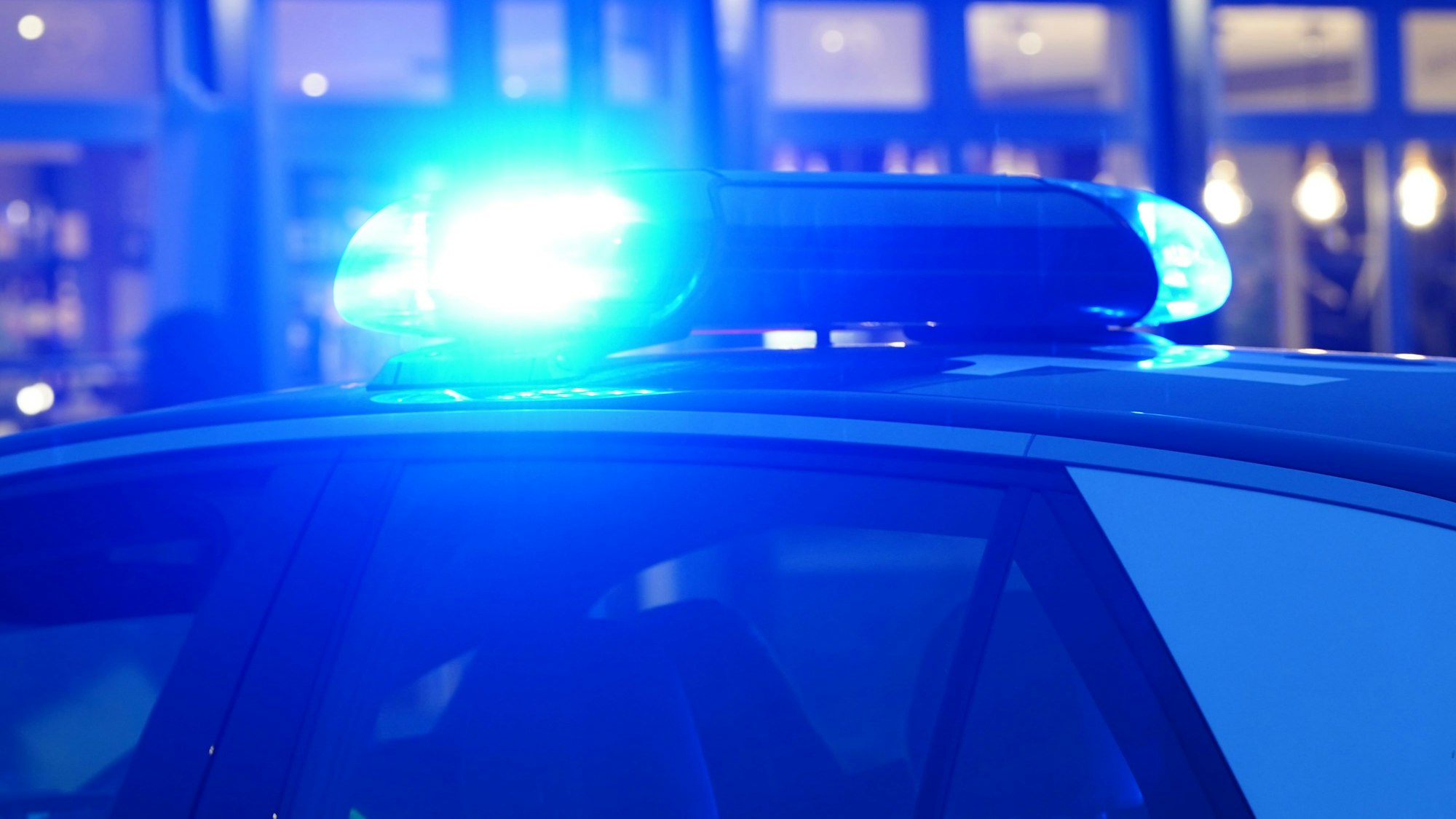 Das Blaulicht eines Polizeiwagens leuchtet.