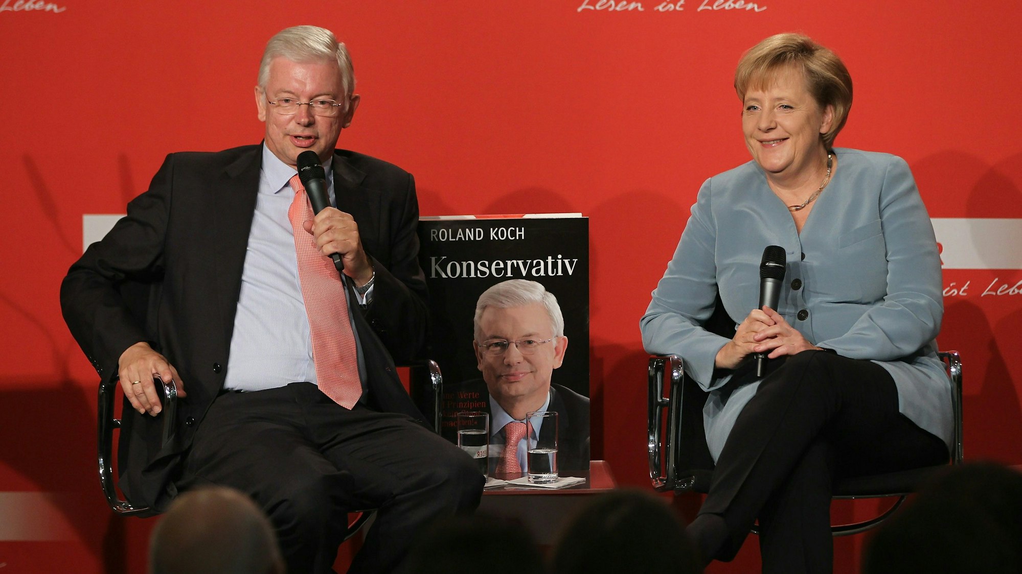Das Bild zeigt Roland Koch (CDU, links) und Angela Merkel (rechts) bei der Vorstellung eines Buches von Koch im Berliner Kulturkaufhaus Dussmann.