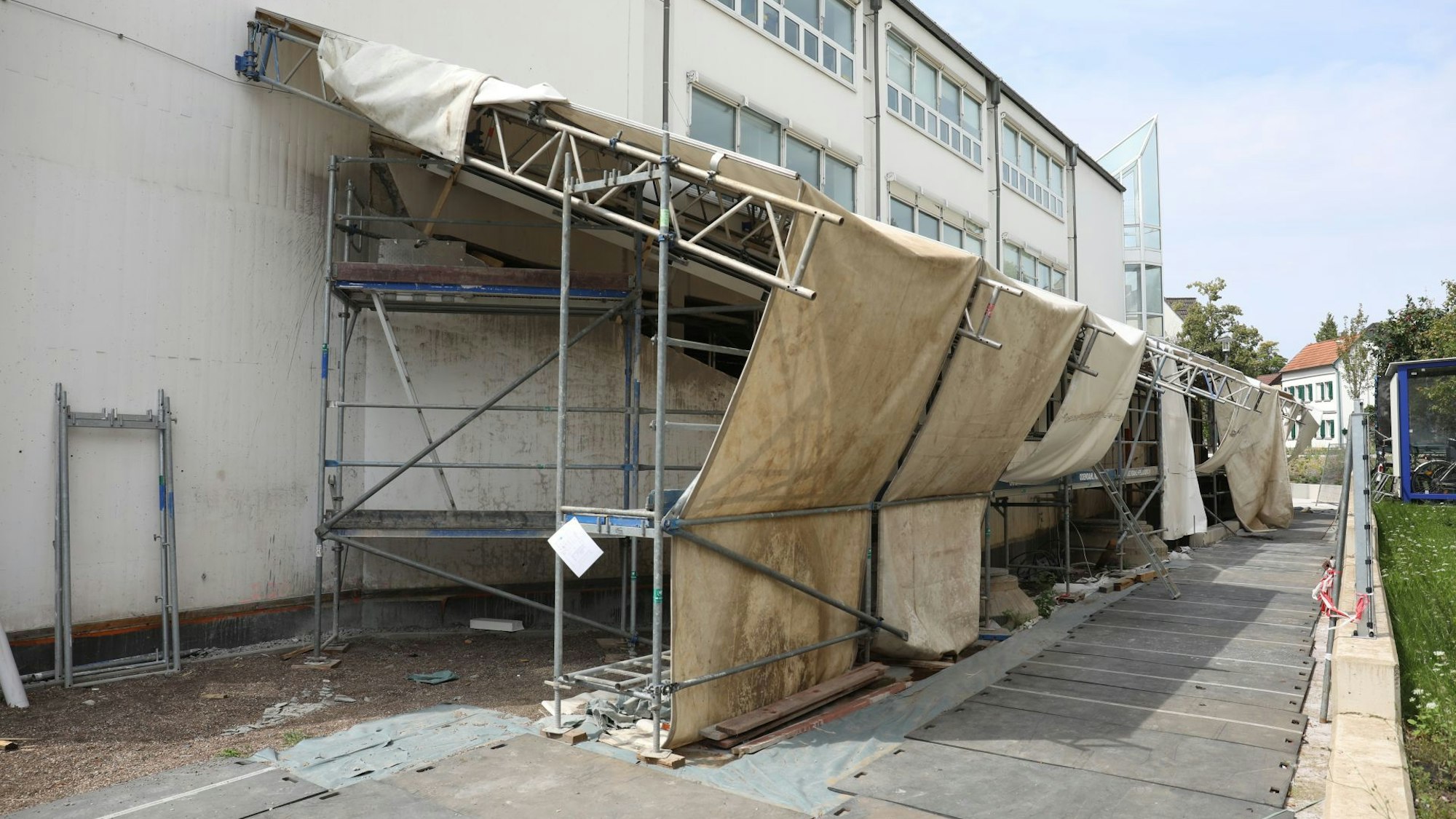 Ein Gebäude, das teilweise eingerüstet und hinter Planen verborgen ist.