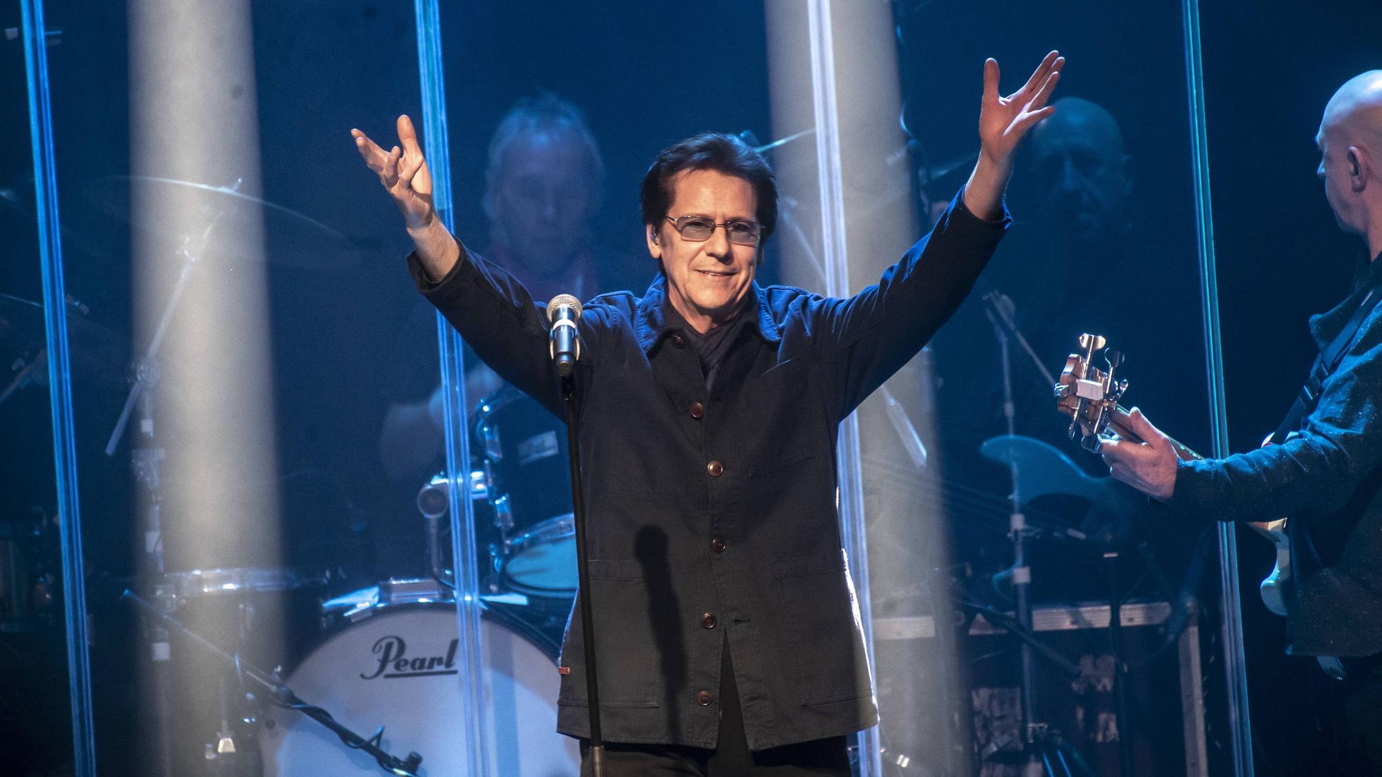 Shakin’ Stevens hebt die Arme auf der Bühne.