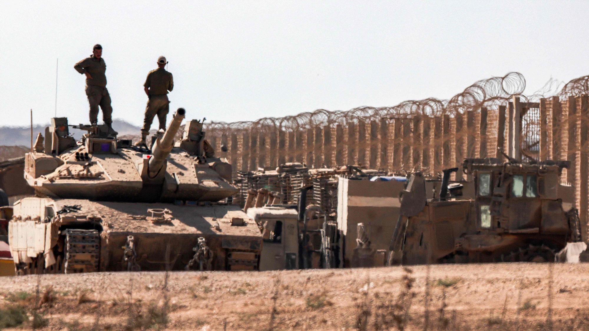 Israelische Soldaten stehen auf einem Panzer am Grenzzaun zum Gazastreifen.
