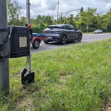 Das Foto zeigt ein Verkehrsmessgerät an einem Schildermast.