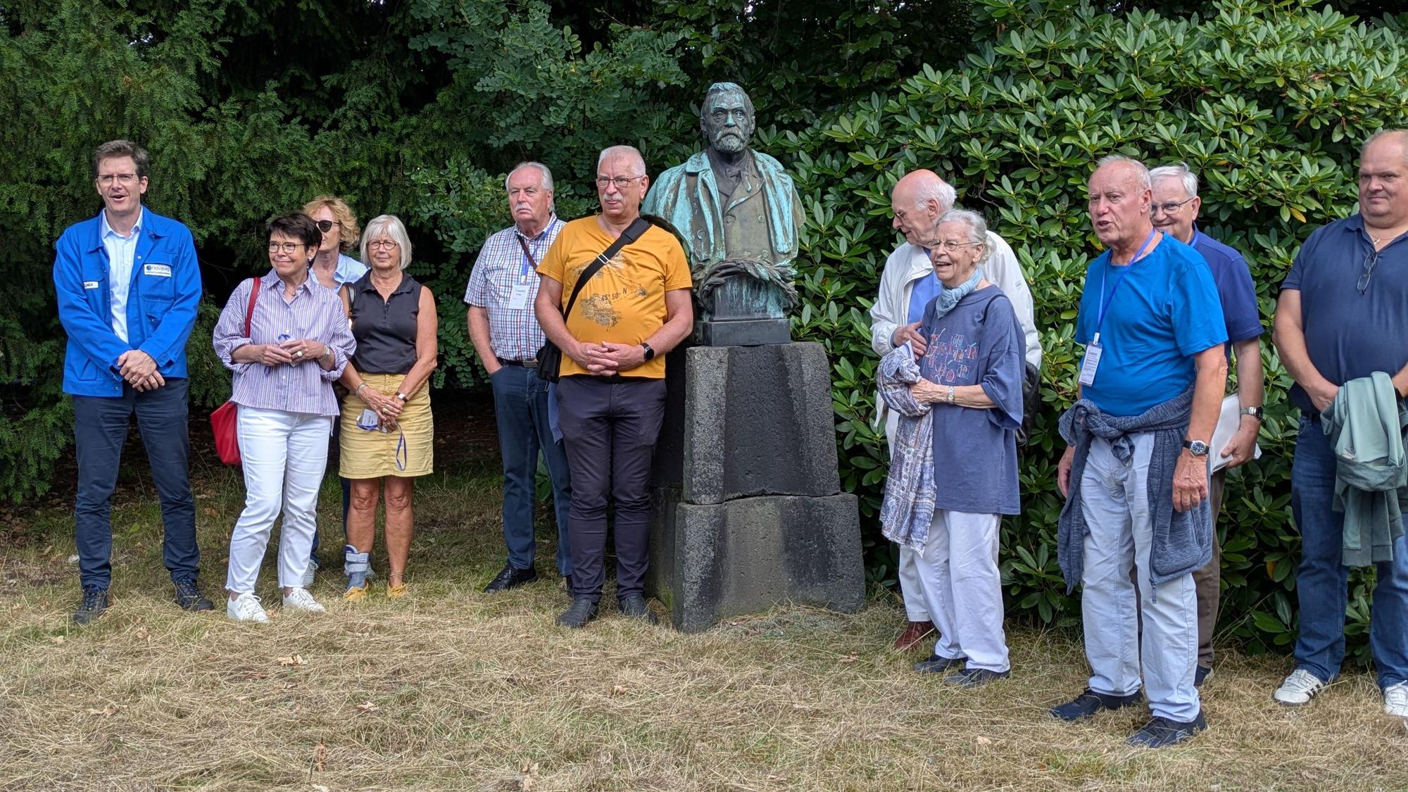 Eine Gruppe von Menschen steht um eine Alfred-Nobel-Büste.