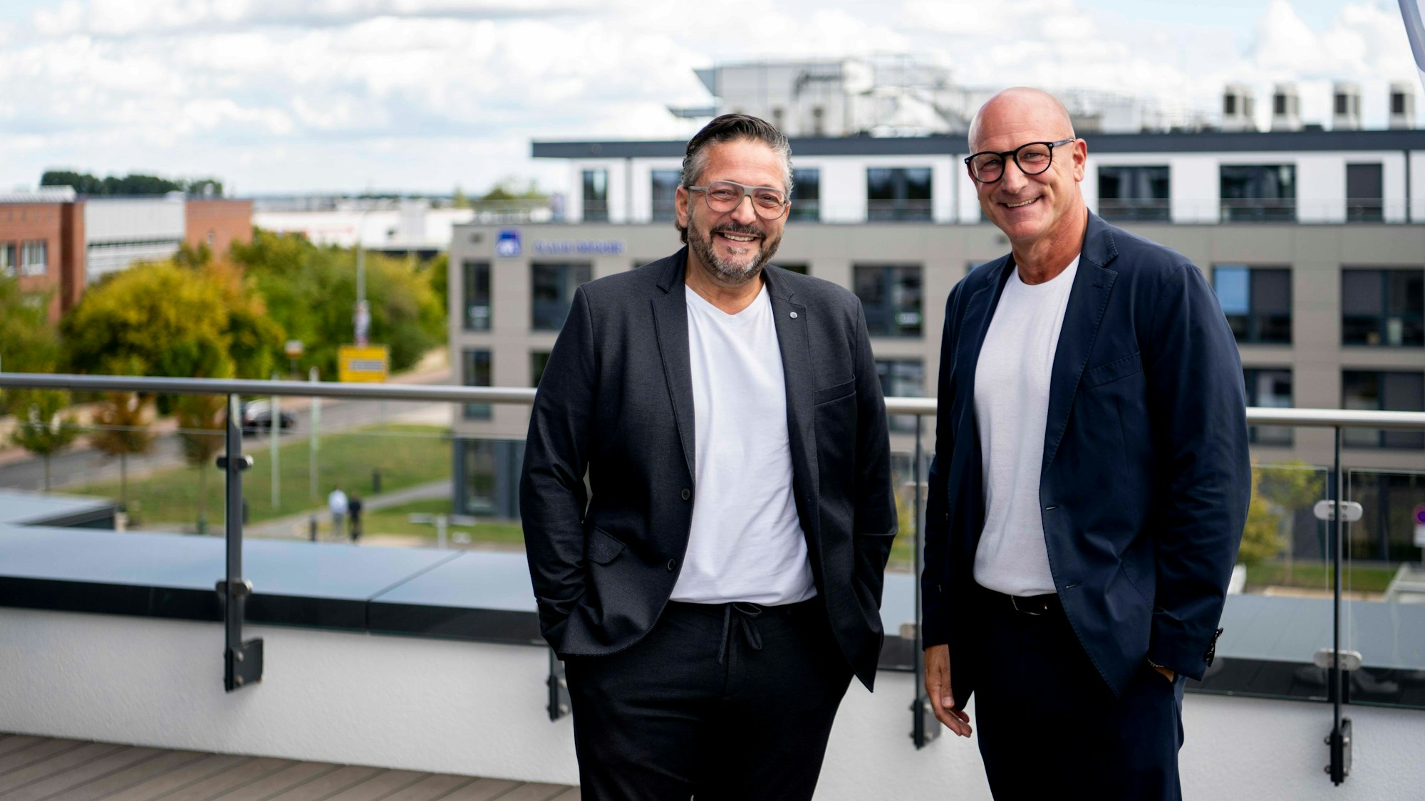 Das Bild zeigt die beiden Bauherren auf dem Dach des Office Park 2. Im Hintergrund ist der Office Park 1 zu sehen.